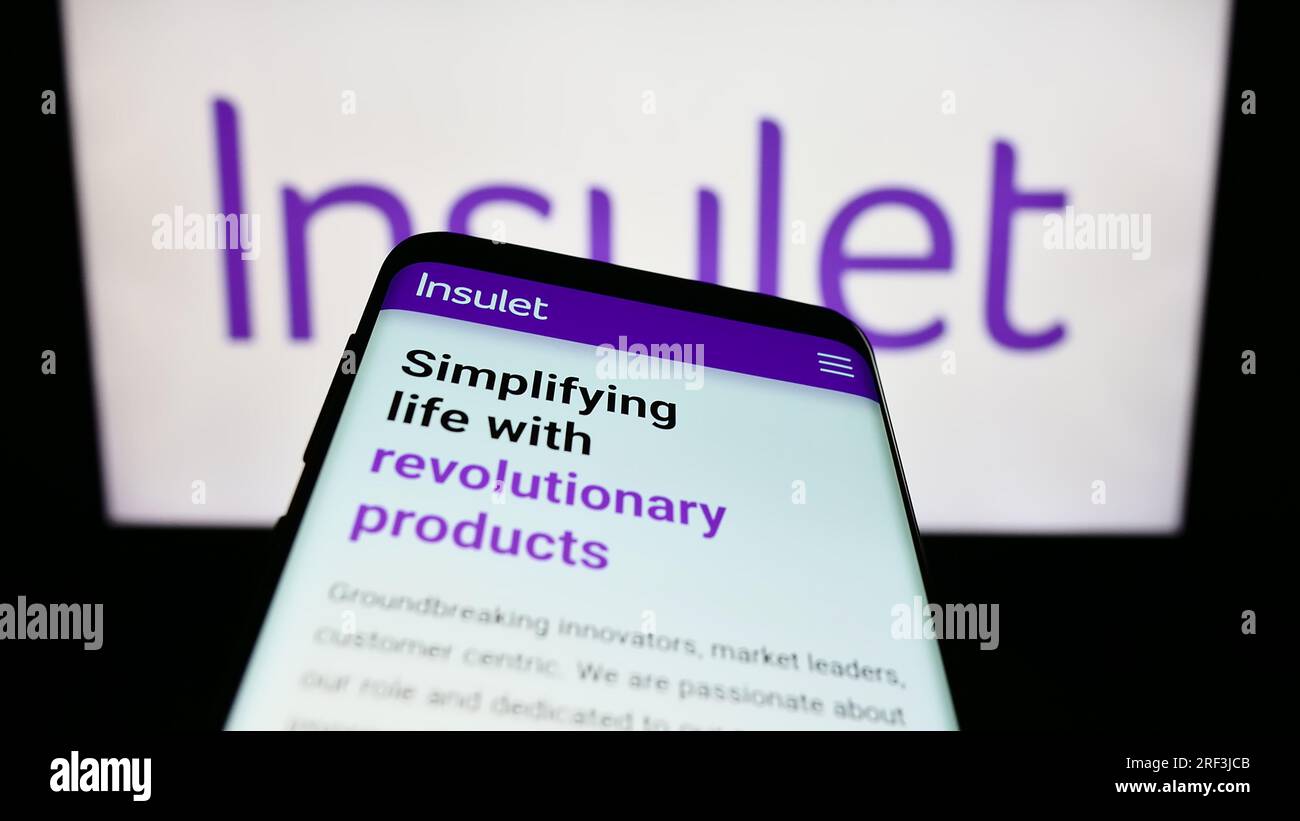 Mobile phone with webpage of US medical device company Insulet Corporation on screen in front of logo. Focus on top-left of phone display. Stock Photo