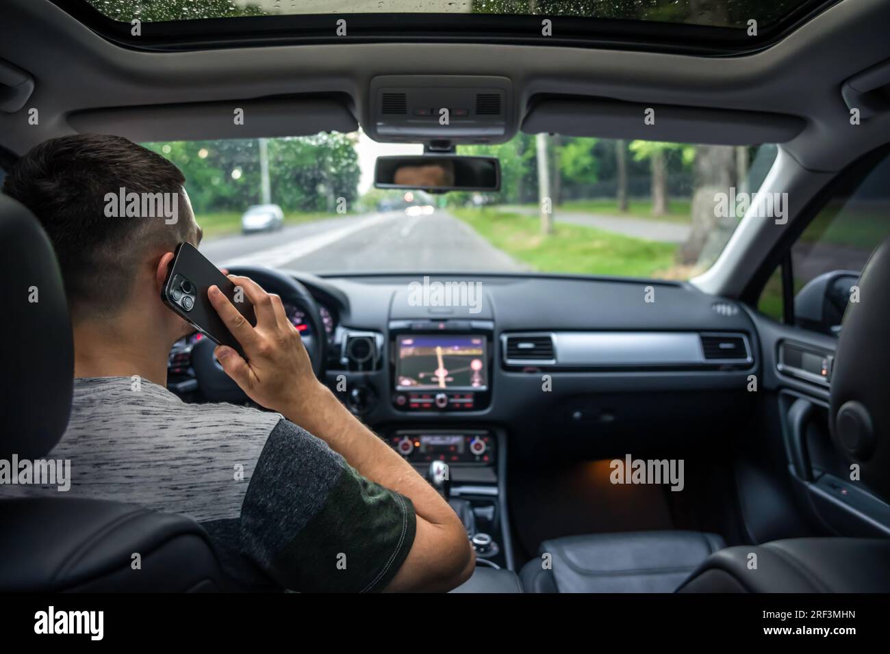 Businessman talking on cell phone while driving. Stock Photo