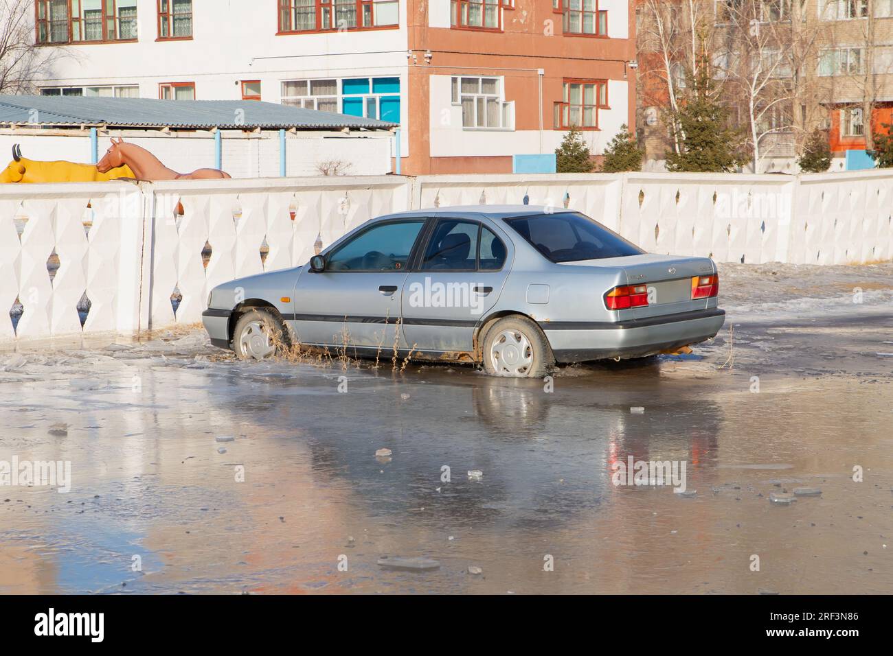old Nissan Primera car in frozen water. winter accident. Pavlodar, Kazakhstan - 12.28.2022. Stock Photo