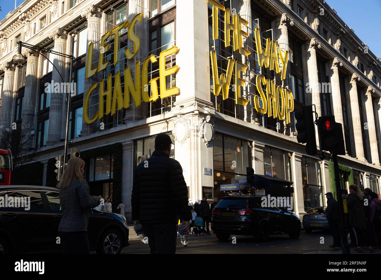 People are silhouetted against Selfridges store on Oxford Street in