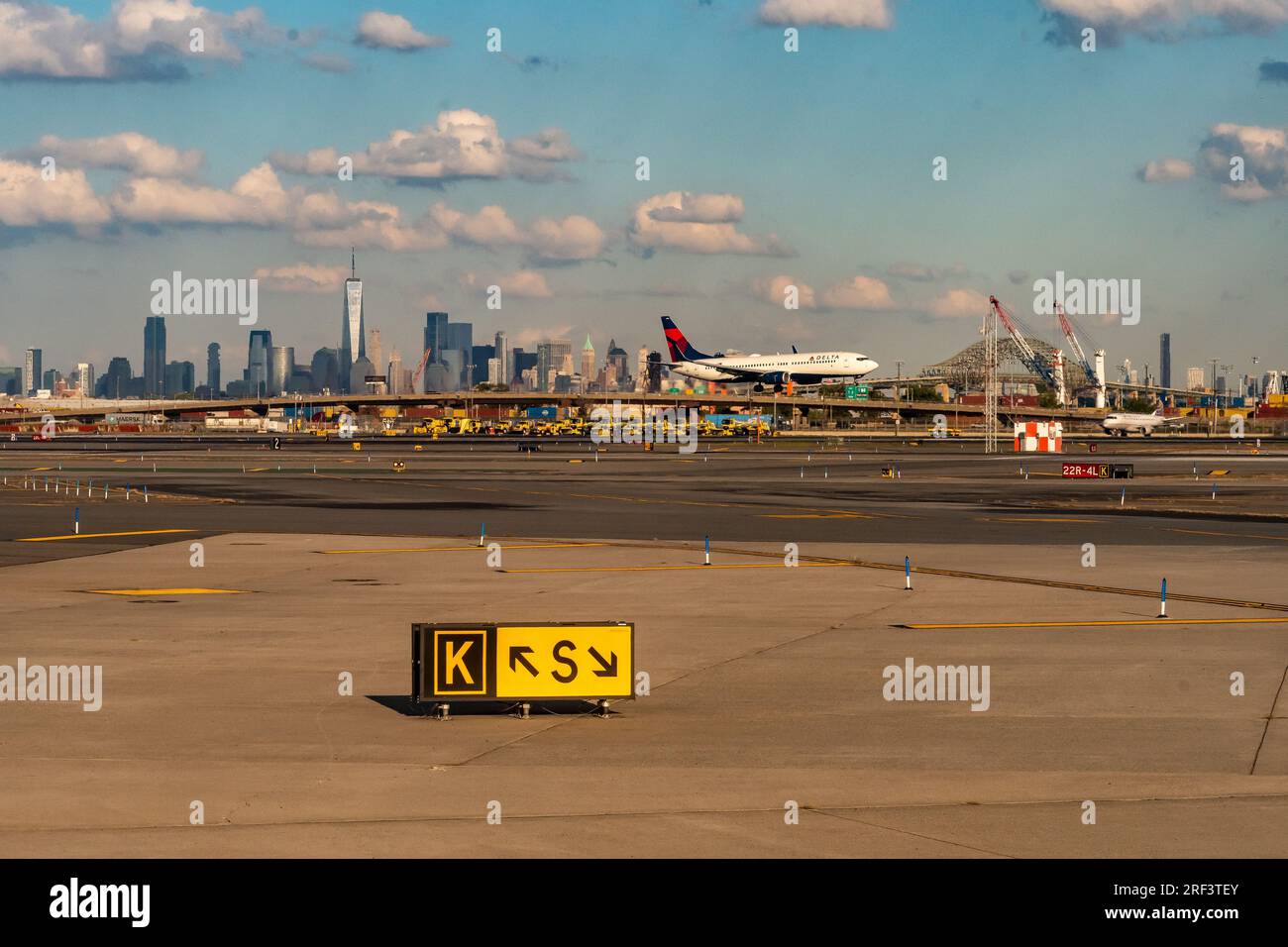 9/27/2022: Newark, New Jersey, USA - A Delta Airlines Jet lands on the runway at Newark Liberty Airport with the New York City Skyline and One WTC Stock Photo