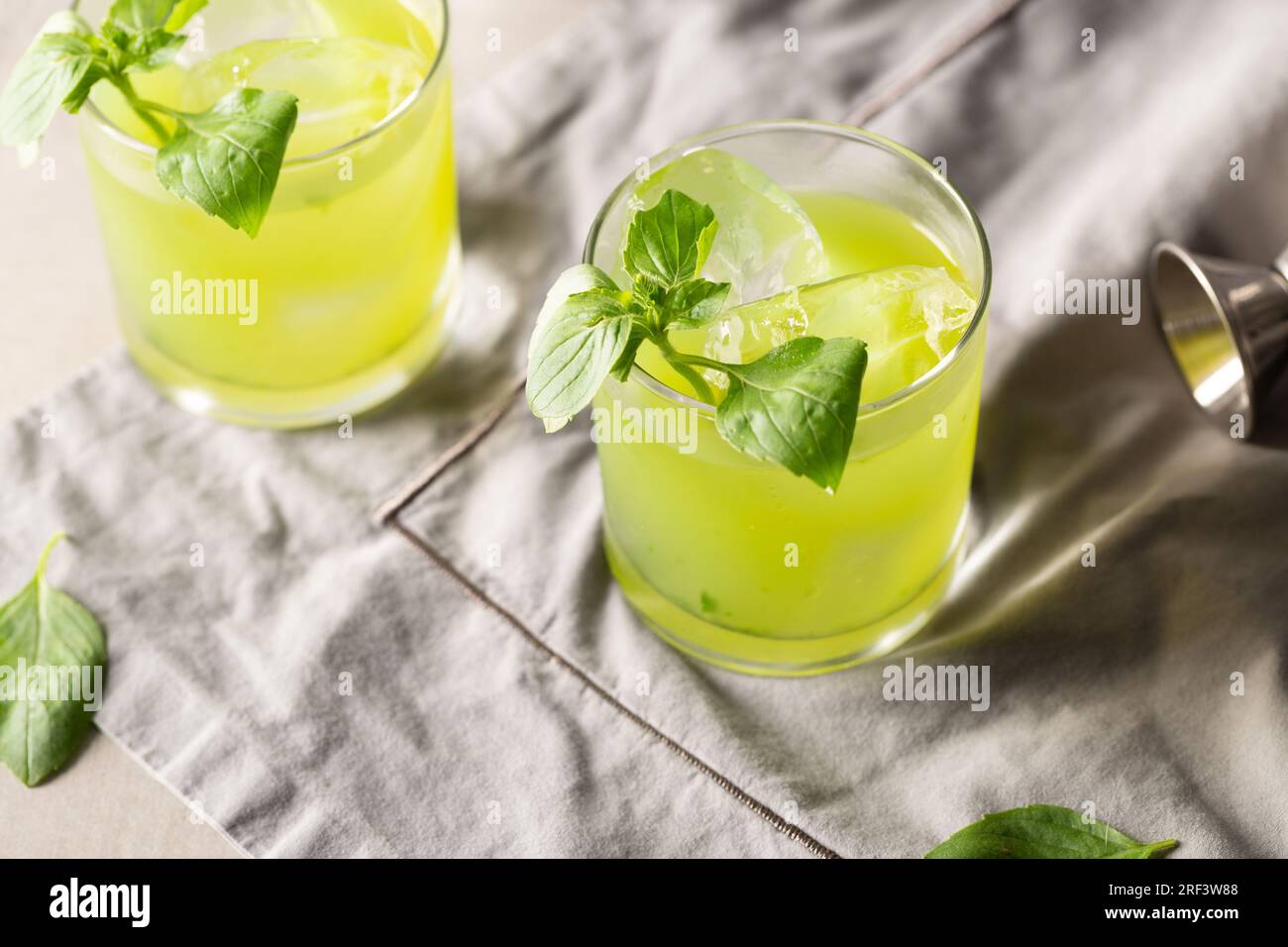 Gin Basil Smash Cocktail booze gin, lemon juice, syrup and basil leaves Stock Photo