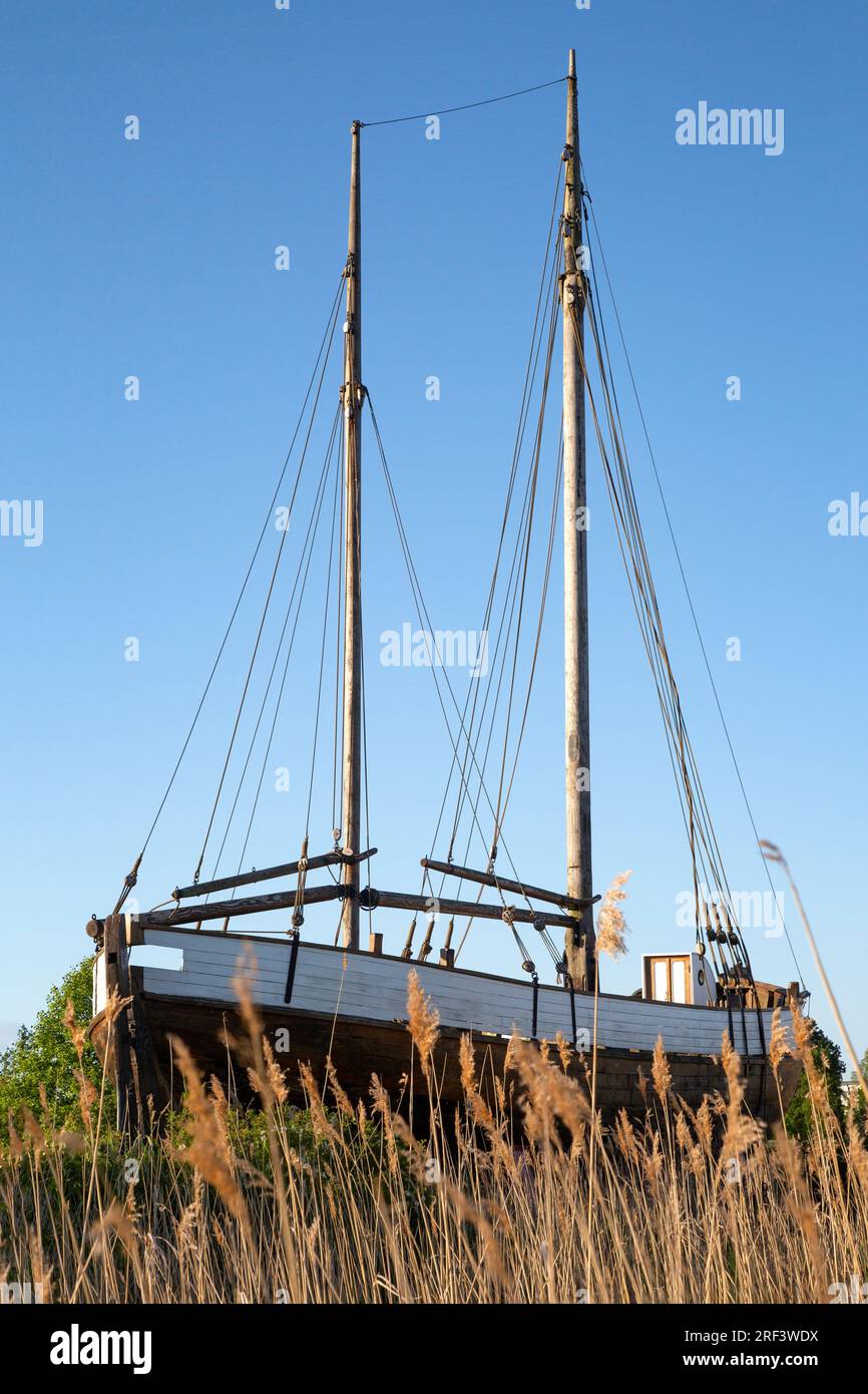 Antique sailing ship stranded behind reed grass Stock Photo