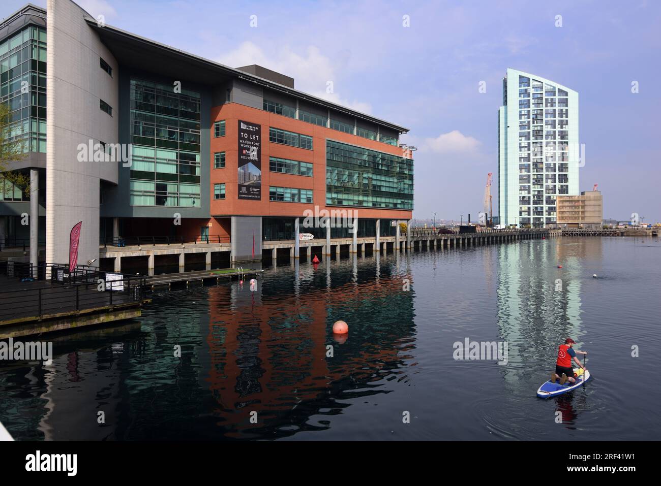 Paddleboarder Paddleboarding in the Prince's Dock with Alexandra Tower (2005-2008) Skyscraper in the Background Liverpool UK Stock Photo