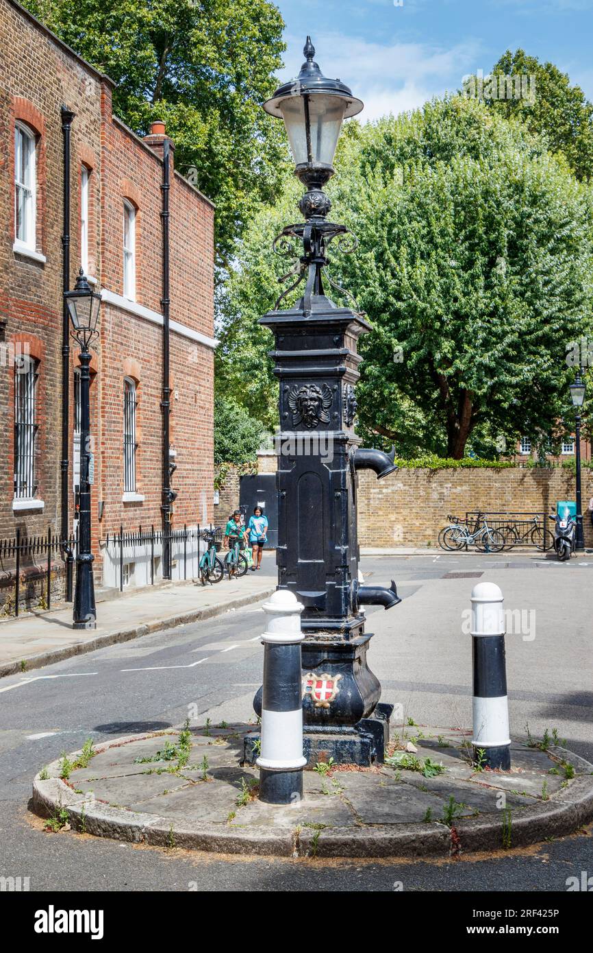 A grade-II listed Georgian public water pump in Bedford Row, Holborn, London, UK. Built in 1826, the pump features two spouts Stock Photo