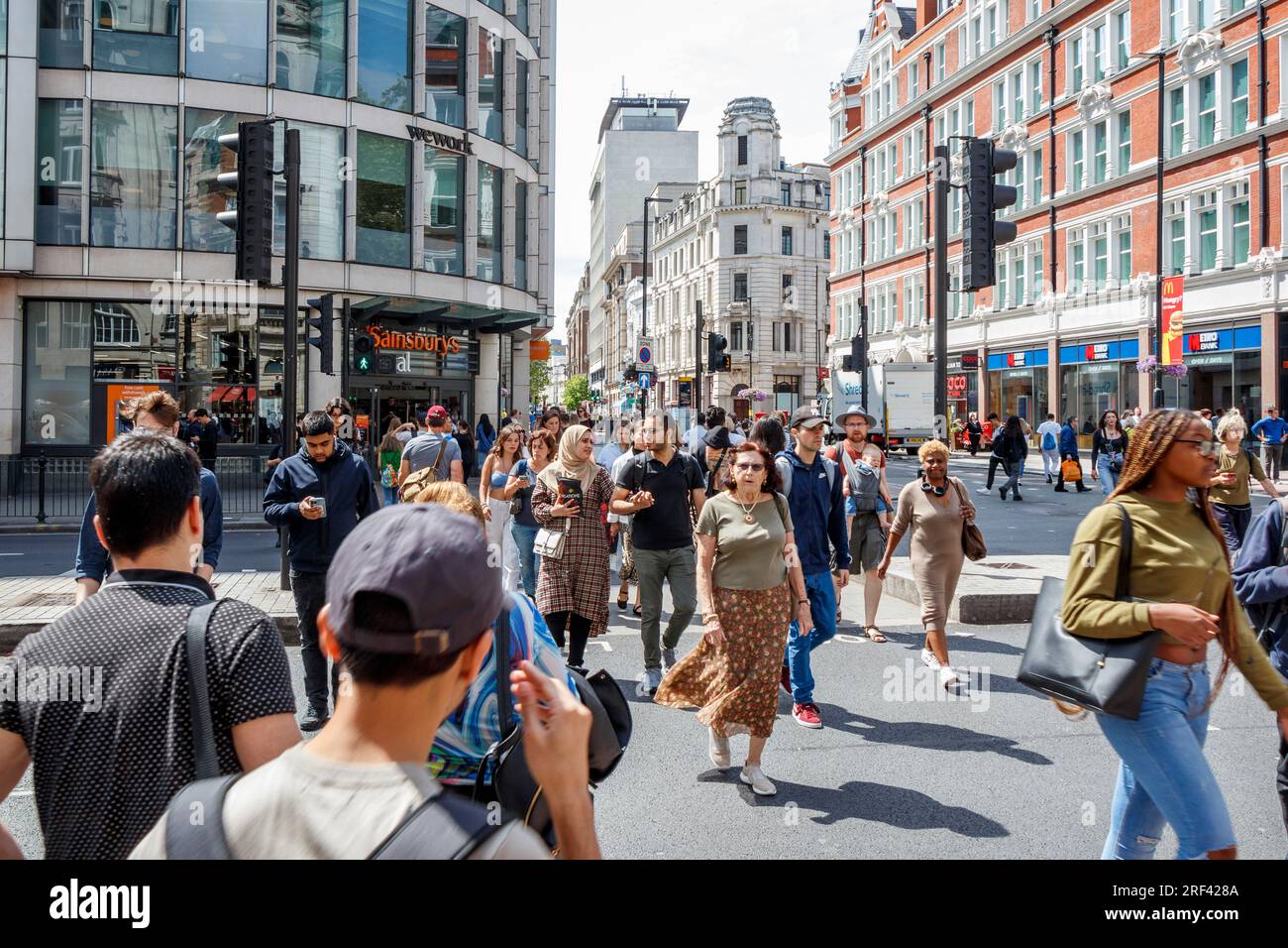 Pedestrians crossing at the intersection of High Holborn and Southampton Row in Central London