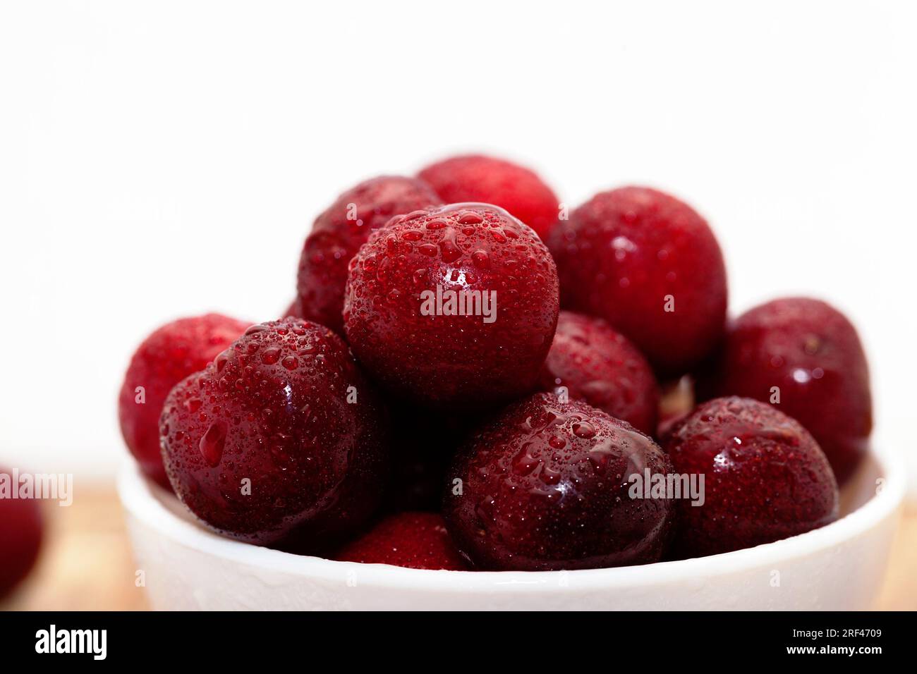 delicious sweet cherries washed and therefore covered with drops of water, fresh edible berries, berries with bones and tails Stock Photo