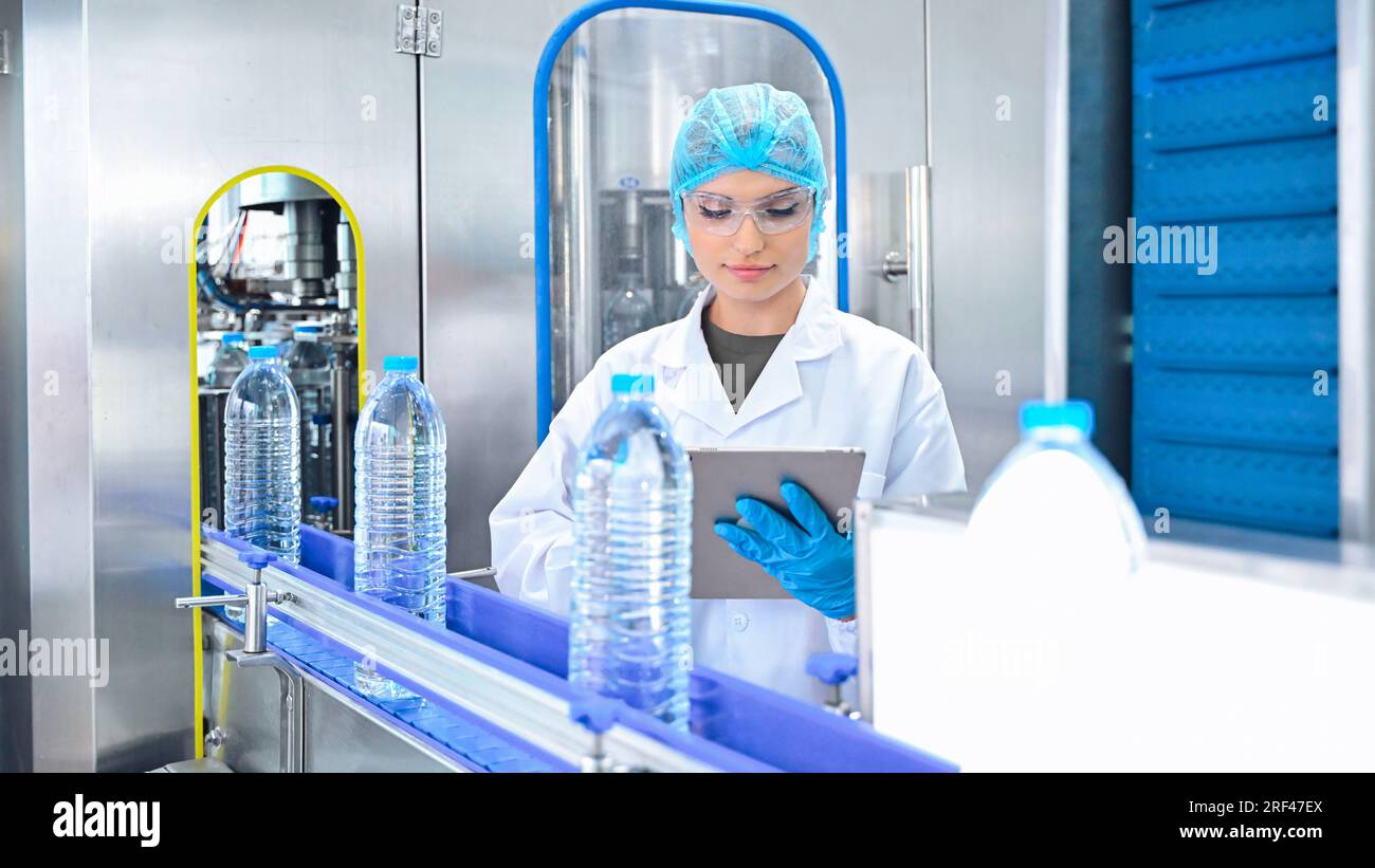 Water Bottle Process Control Bottling factory worker inspecting quality of water bottles before ...