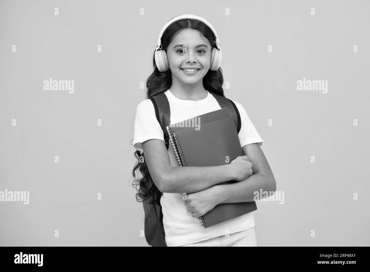 Back to school. Teenager school girl with backpack and headphones hold ...