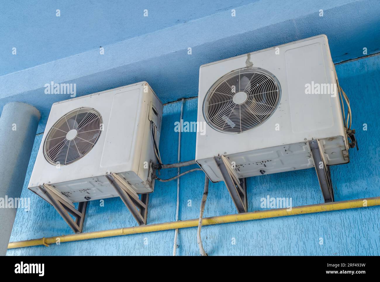 White air conditioners on blue wall of the house. Modern climate