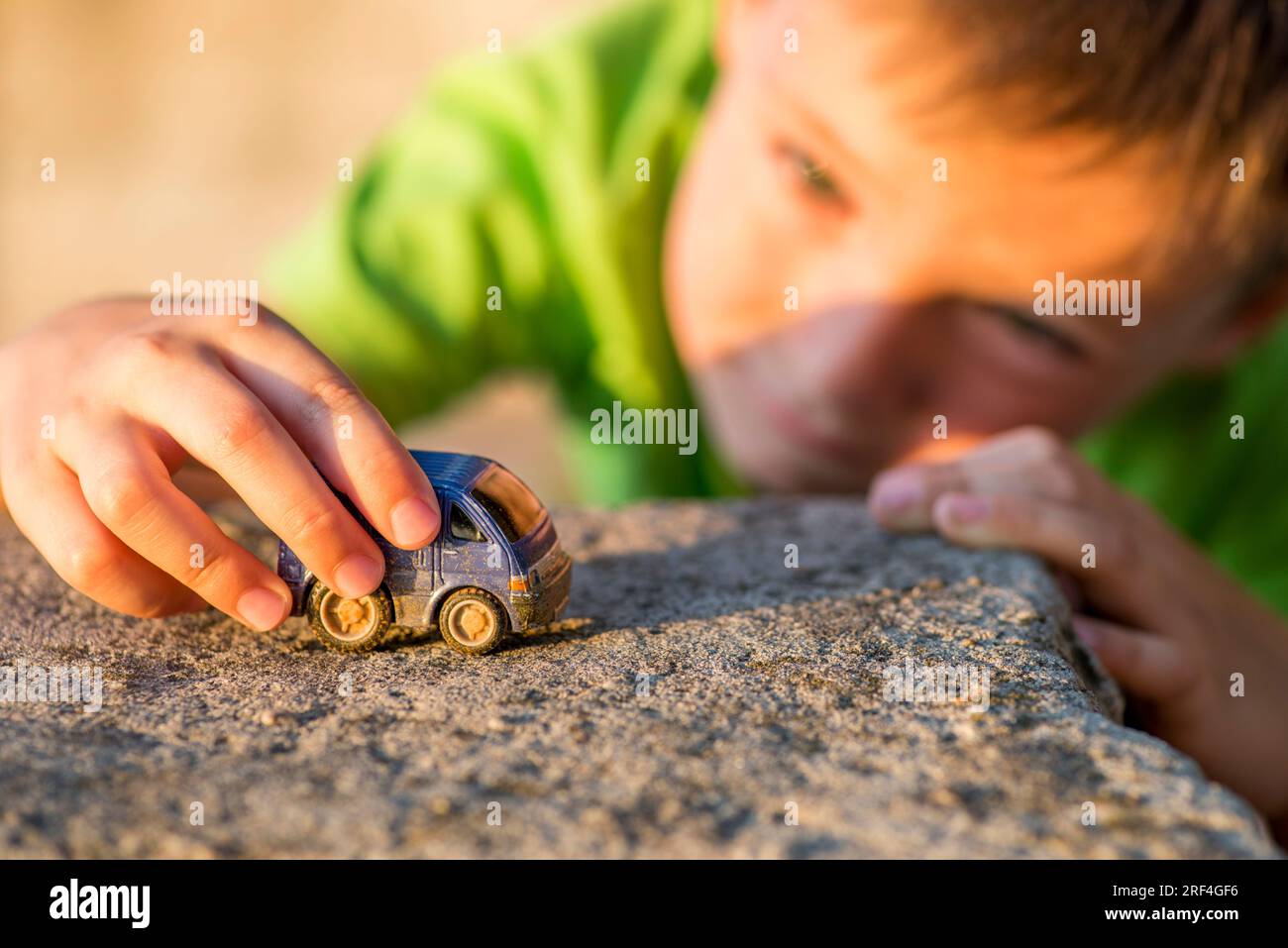 Cute little boy is playing with little toy car outdoor Stock Photo - Alamy