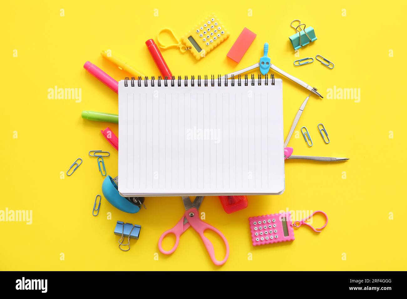 Composition with blank notebook and school stationery on yellow ...