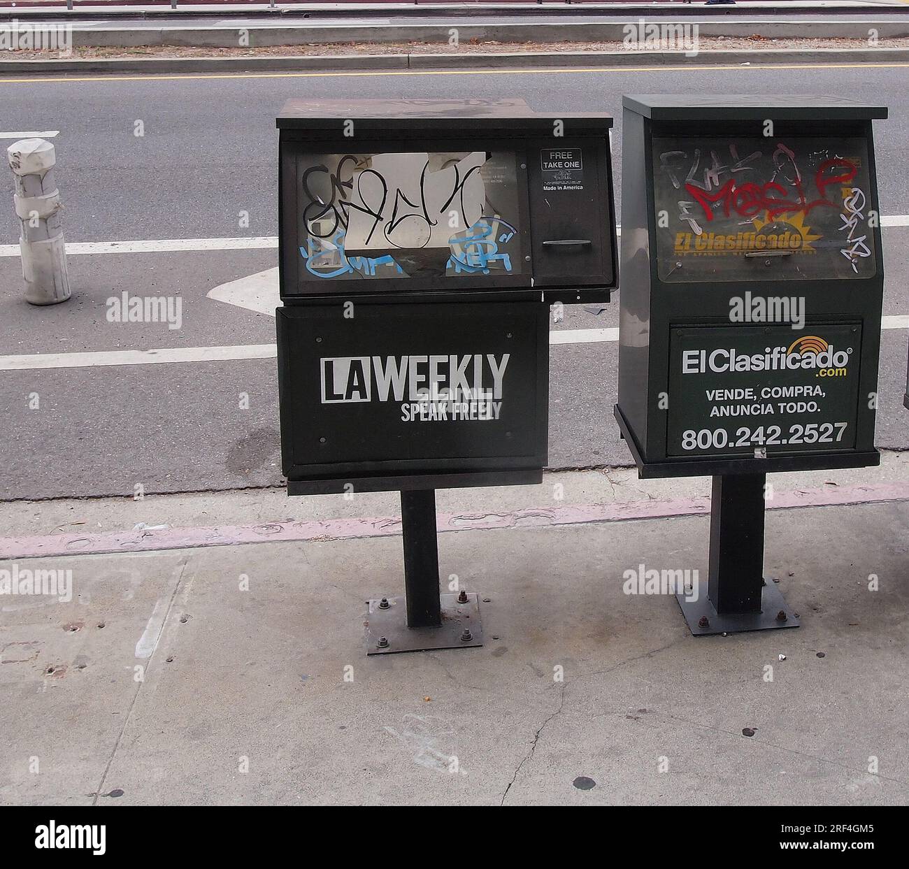 graffiti on sidewalk newspaper boxes in Los Angeles, California Stock