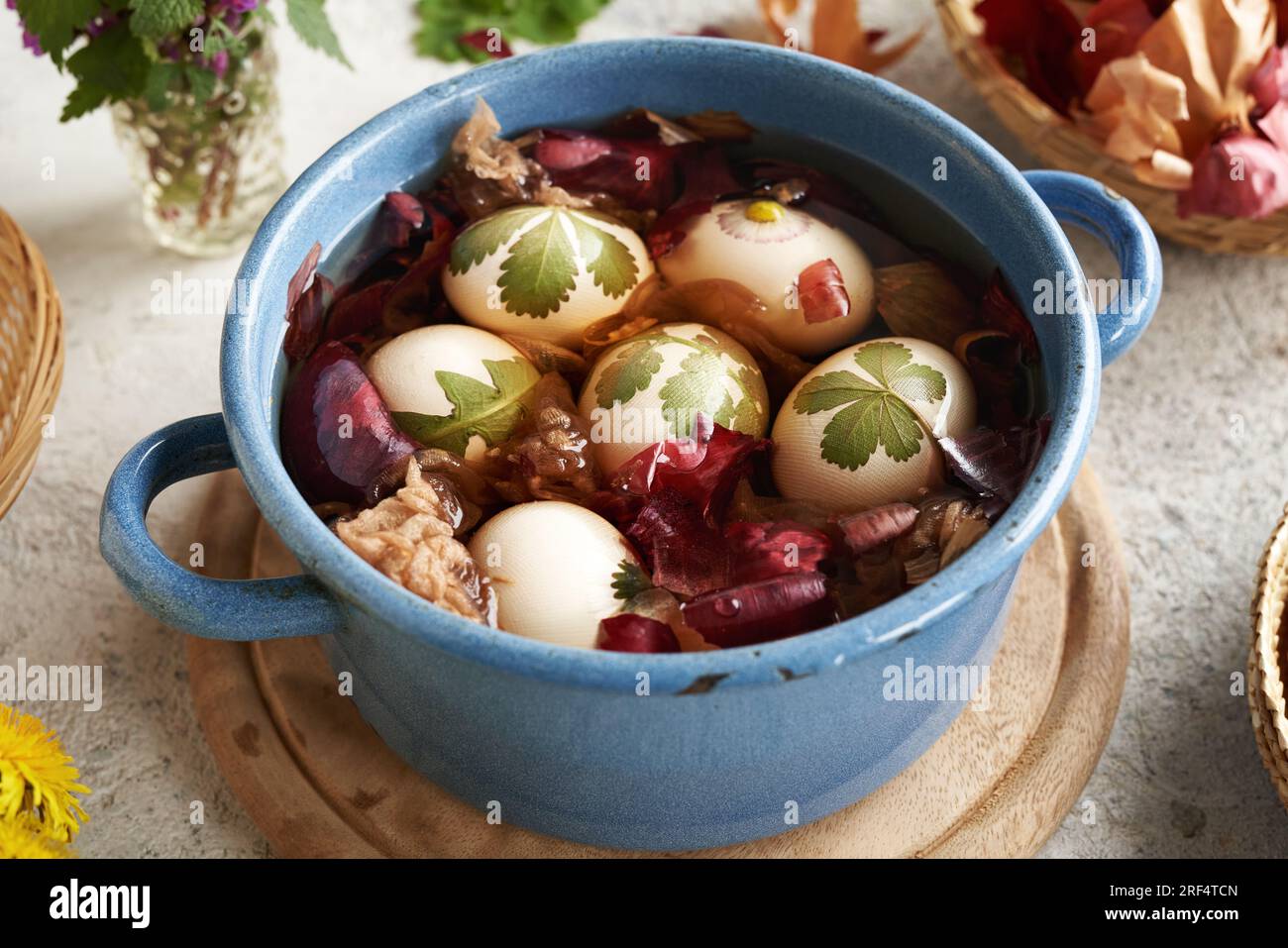 Easter eggs with fresh leaves attached to them immersed in water with onion skins preparation
