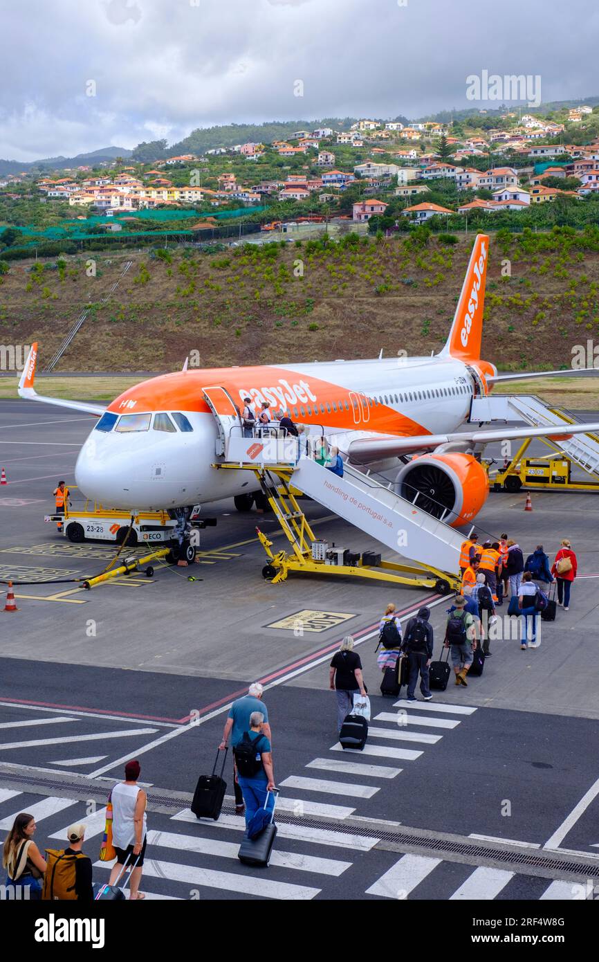 Air travel, Easyjet plane, passengers in queue boarding an Easyjet airplane Airbus A320 in Summer, Madeira Island Airport tarmac, Portugal Stock Photo