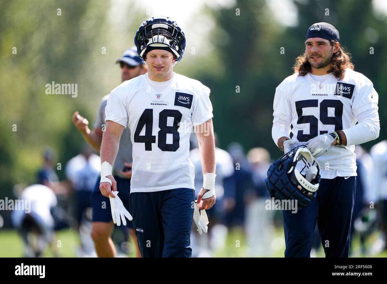 Seattle Seahawks linebacker Ben Burr-Kirven (48) and linebacker Jon  Rhattigan (59) walk off the field following a 'Back Together Weekend' event  at the NFL football team's training facility, Sunday, July 30, 2023,