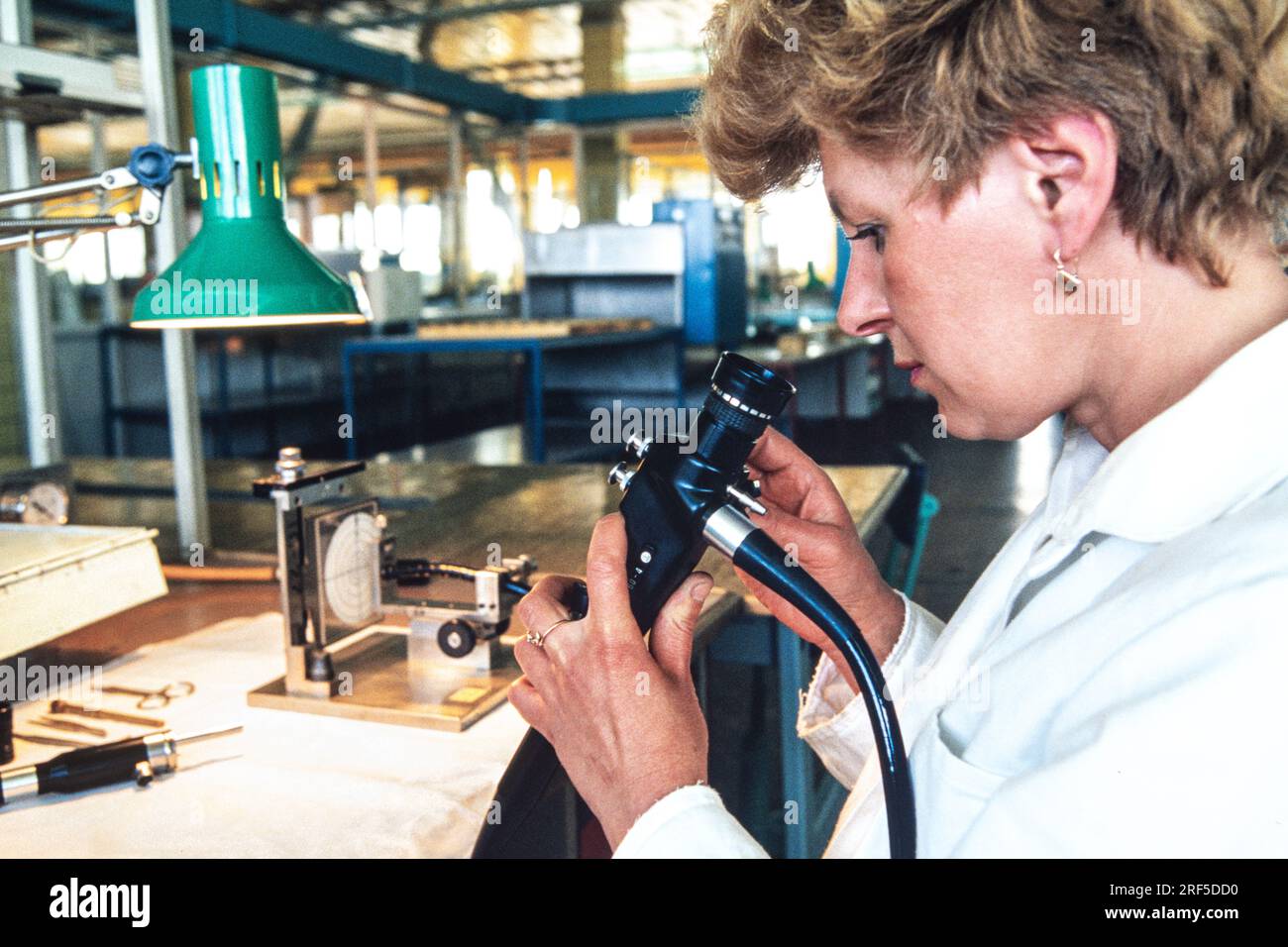 A technician checks the optical alignment of an endoscope after assembly at the LOMO Optical Factory, December 10, 1994 in St. Petersburg, Russia. The Leningrad Optical Mechanical Association begun production in 1914 under the Soviet Union and was privatized in 1994 specializing in cameras, telescopes, microscopes and endoscopes. Stock Photo