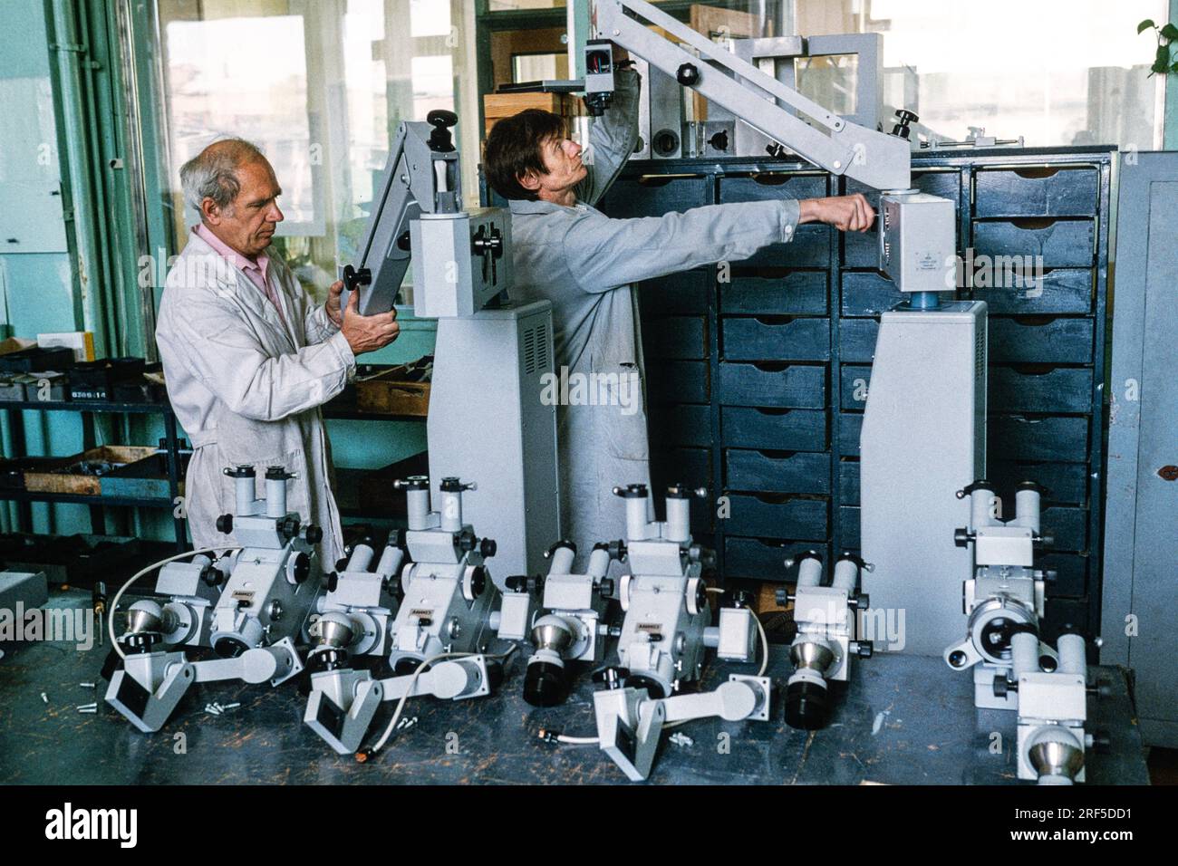 Technicians check optical instruments after assembly at the LOMO Optical Factory, December 10, 1994 in St. Petersburg, Russia. The Leningrad Optical Mechanical Association begun production in 1914 under the Soviet Union and was privatized in 1994 specializing in cameras, telescopes, microscopes and endoscopes. Stock Photo