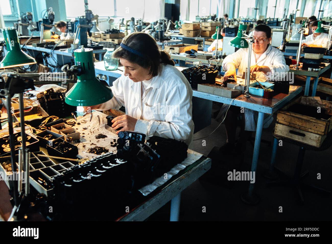 Technicians assemble tiny parts used in optical equipment by hand at the LOMO Optical Factory, December 10, 1994 in St. Petersburg, Russia. The Leningrad Optical Mechanical Association begun production in 1914 under the Soviet Union and was privatized in 1994 specializing in cameras, telescopes, microscopes and endoscopes. Stock Photo