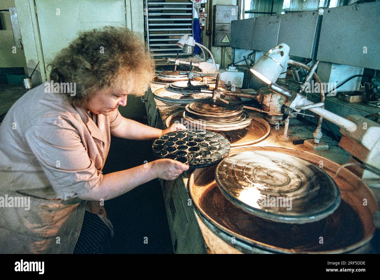 A technician prepares to hand grind optical lenses at the LOMO Optical Factory, December 10, 1994 in St. Petersburg, Russia. The Leningrad Optical Mechanical Association begun production in 1914 under the Soviet Union and was privatized in 1994 specializing in cameras, telescopes, microscopes and endoscopes. Stock Photo