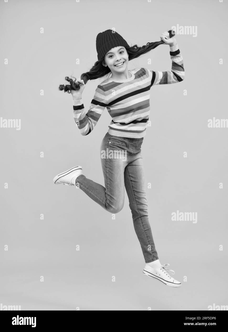 Modern teenage girl 12, 13, 14 year old wearing sweater and knitted hat