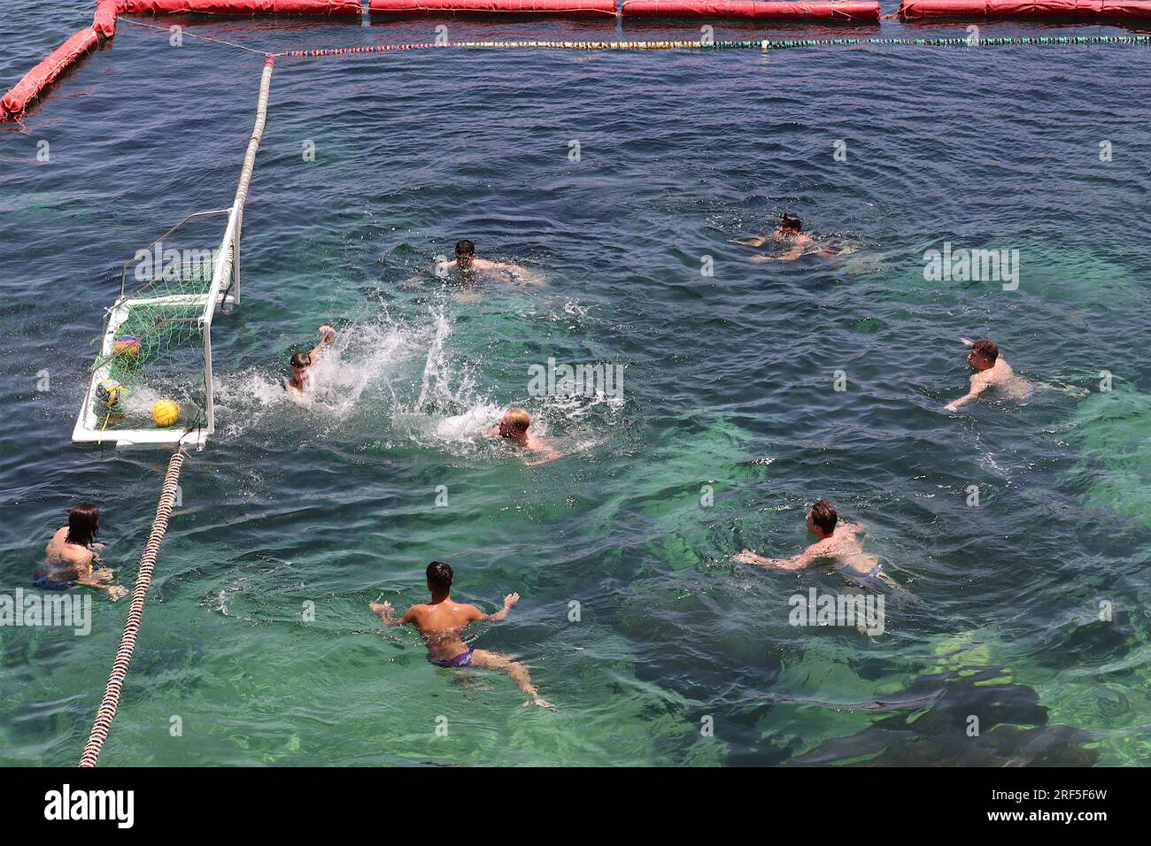 GOAL!! Water polo players during a training session in a sectioned off part of the Mediterranean bay at Marsalforn, Gozo, Malta, June 2022. Stock Photo