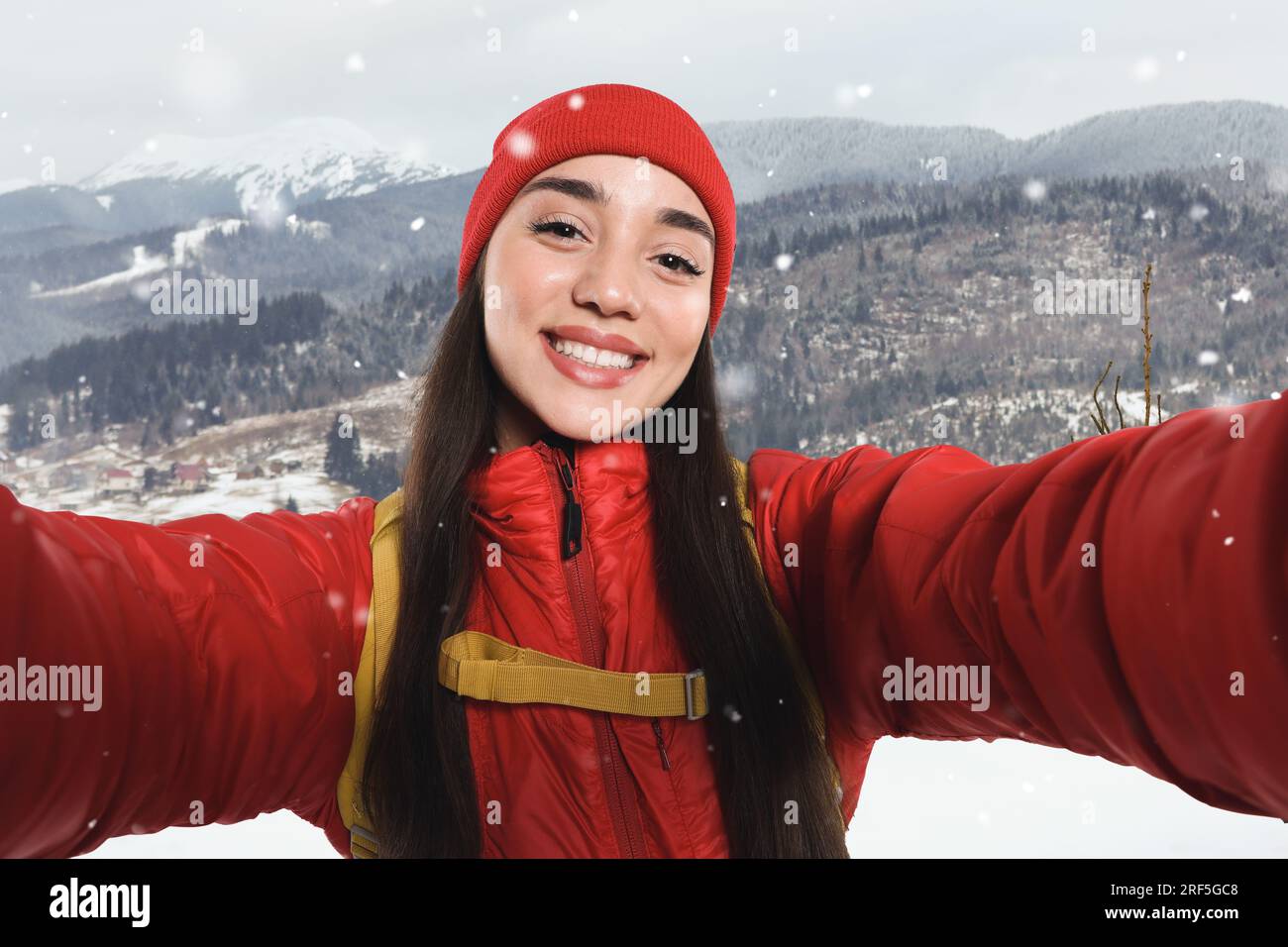  Happy tourist with backpack taking selfie in snowy mountains Stock ...