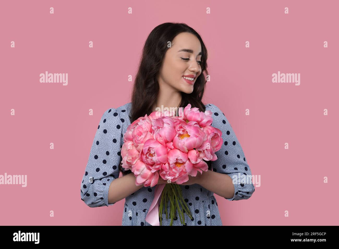 Beautiful young woman with bouquet of peonies on pink background Stock ...
