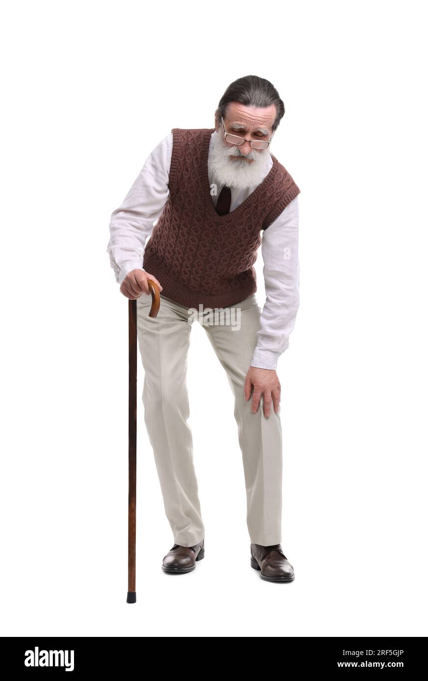 Senior man with walking cane suffering from knee pain on white