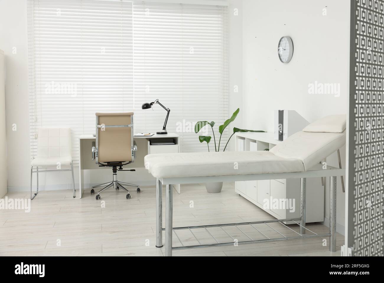 Modern medical office with doctor's workplace and examination table in ...