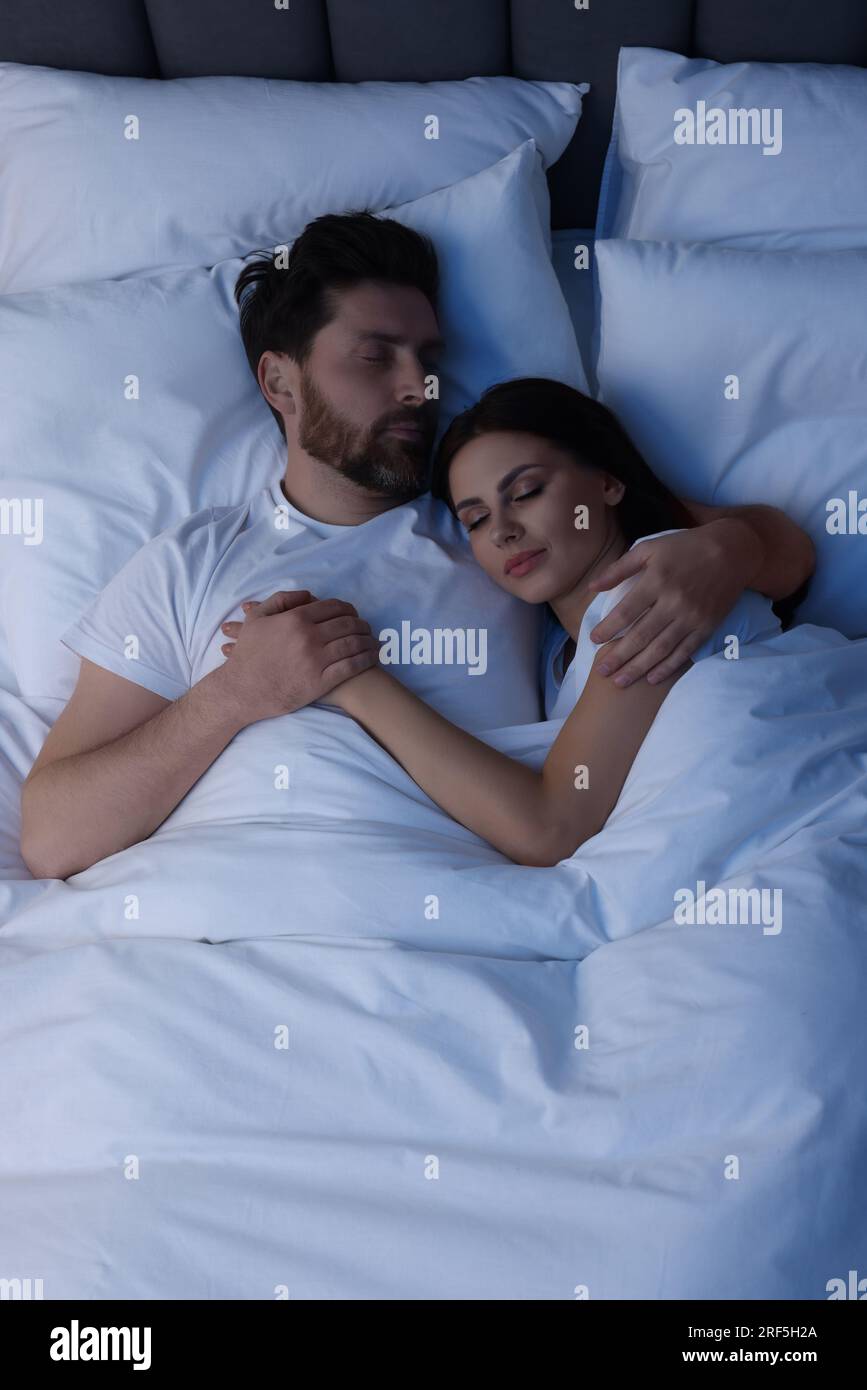 Lovely couple sleeping together in bed at night, top view Stock Photo ...
