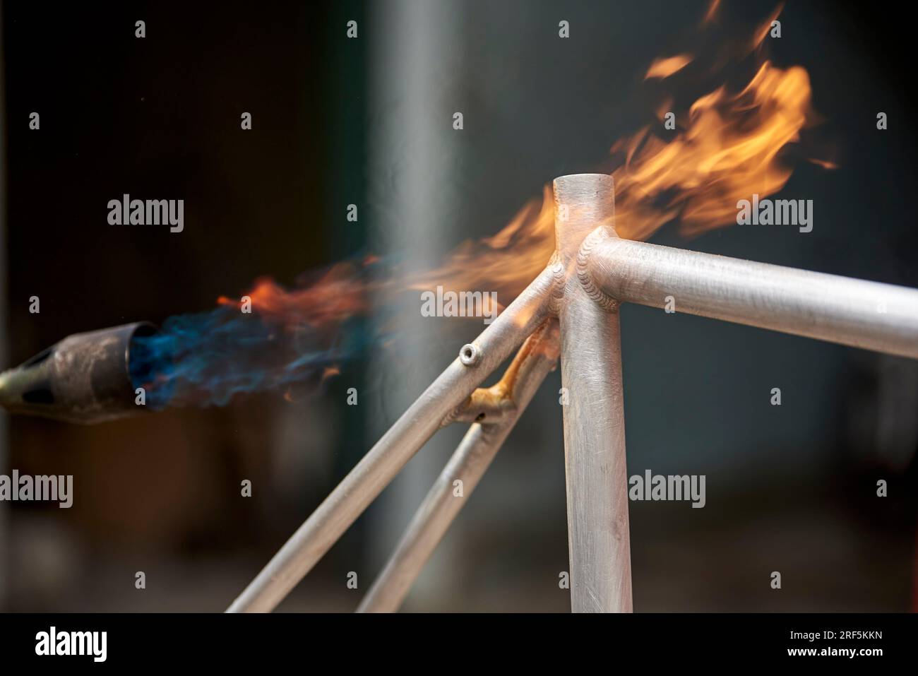 Manual bicycle renovation work, paint removal process using a torch