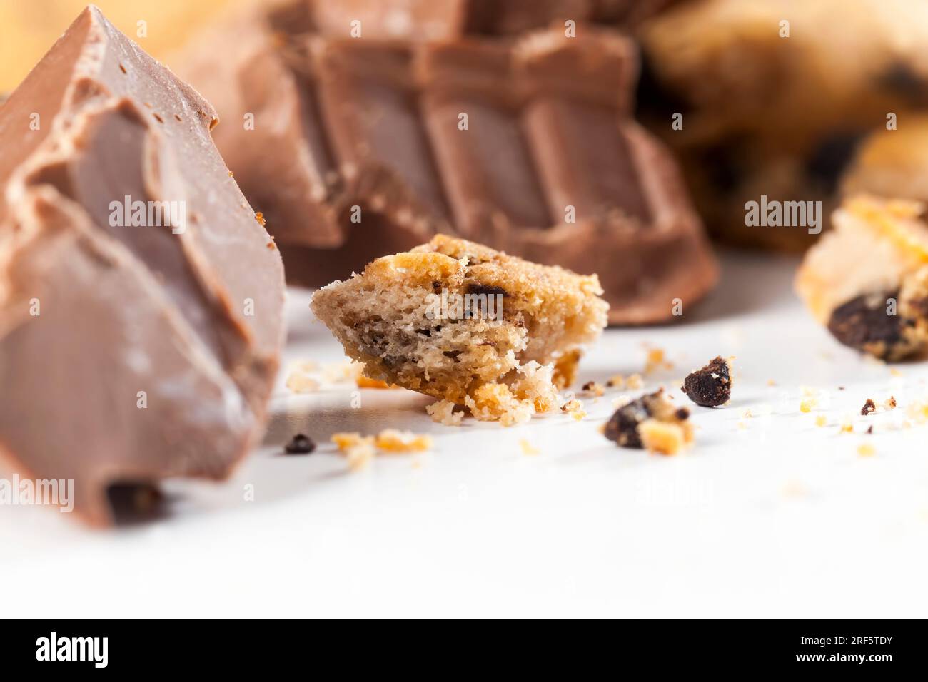 broken wheat flour cookies and large pieces of sweet chocolate together, cookies with chocolate pieces inside, closeup food for desserts crumbled cook Stock Photo