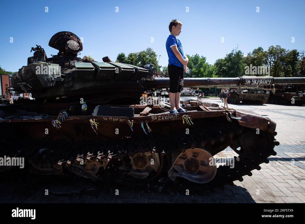 Kyiv, Ukraine. 28th July, 2023. A boy stands on a destroyed Russian tank on display in central Kyiv. Credit: SOPA Images Limited/Alamy Live News Stock Photo