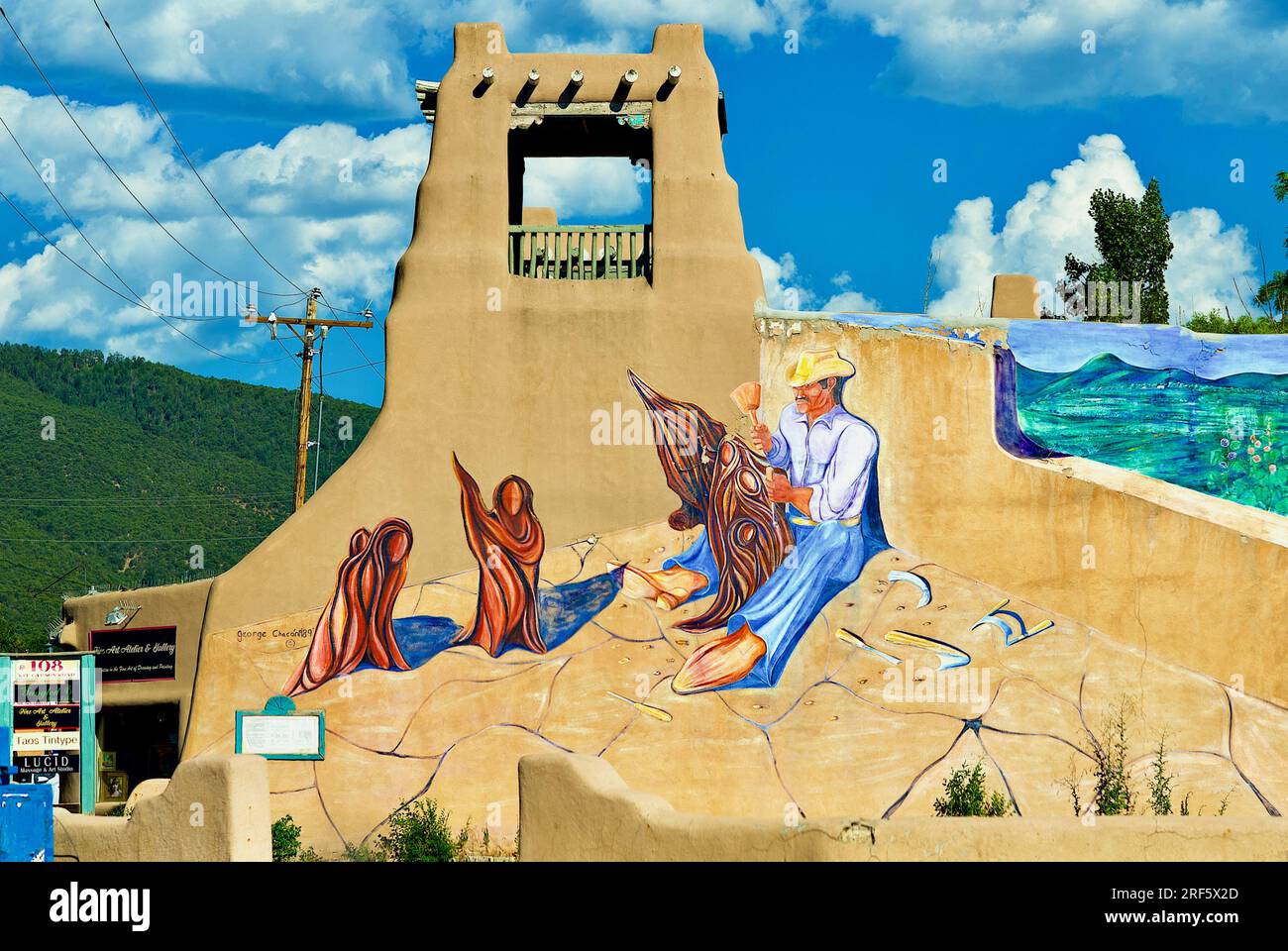 Taos, New Mexico, USA - July 23, 2023: A colorful scene is painted on a traditional adobe building near the Taos Plaza in historic downtown Taos. Stock Photo