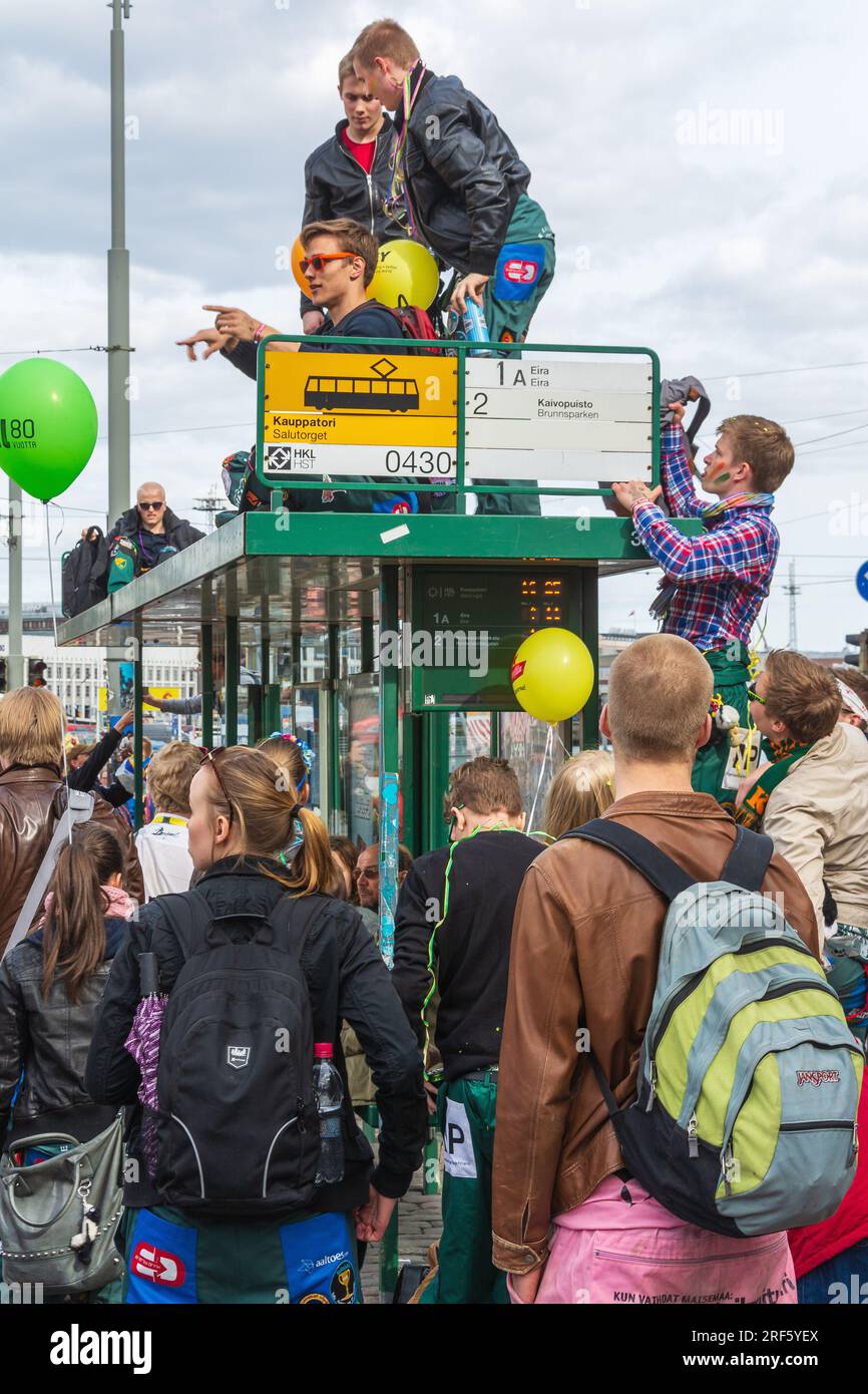 People celebrating May Day Eve on Tram stop canopy at Kauppatori in