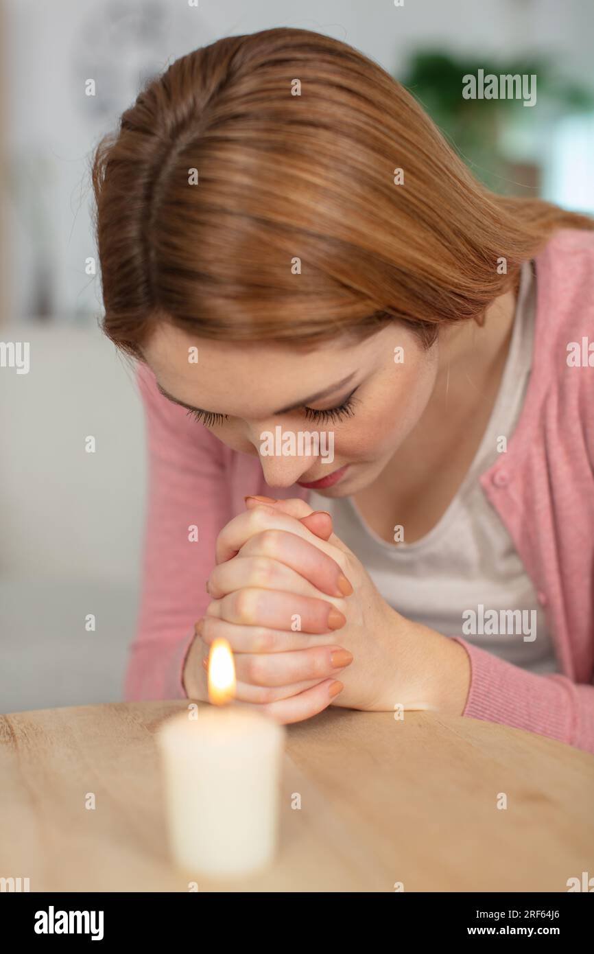 young woman praying meditating at home Stock Photo