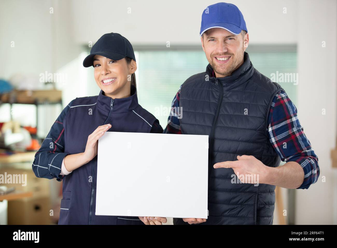 work colleagues holding blank sign Stock Photo - Alamy