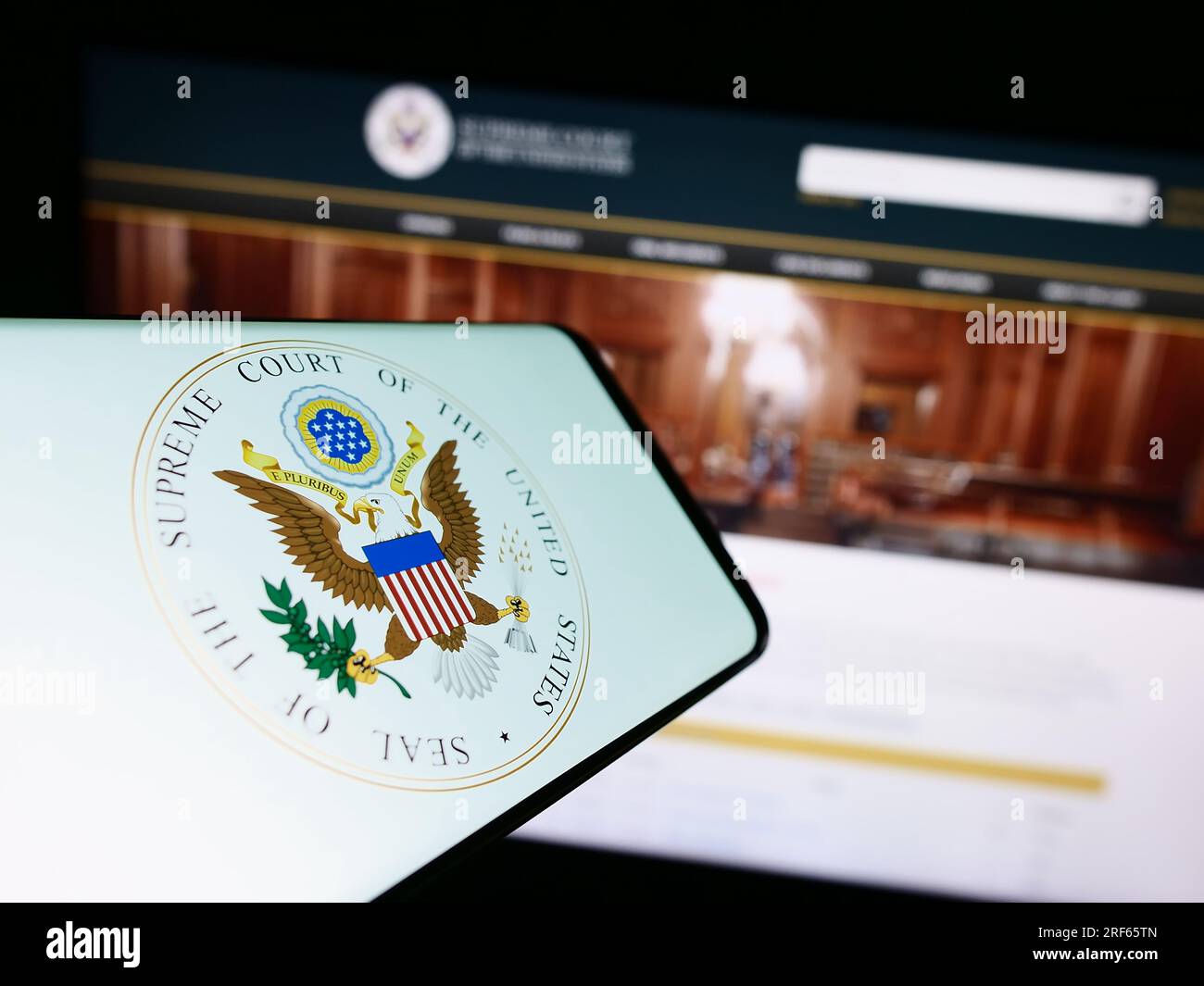 Smartphone with seal of the US Supreme Court (SCOTUS) on screen in front of website. Focus on center of phone display. Stock Photo