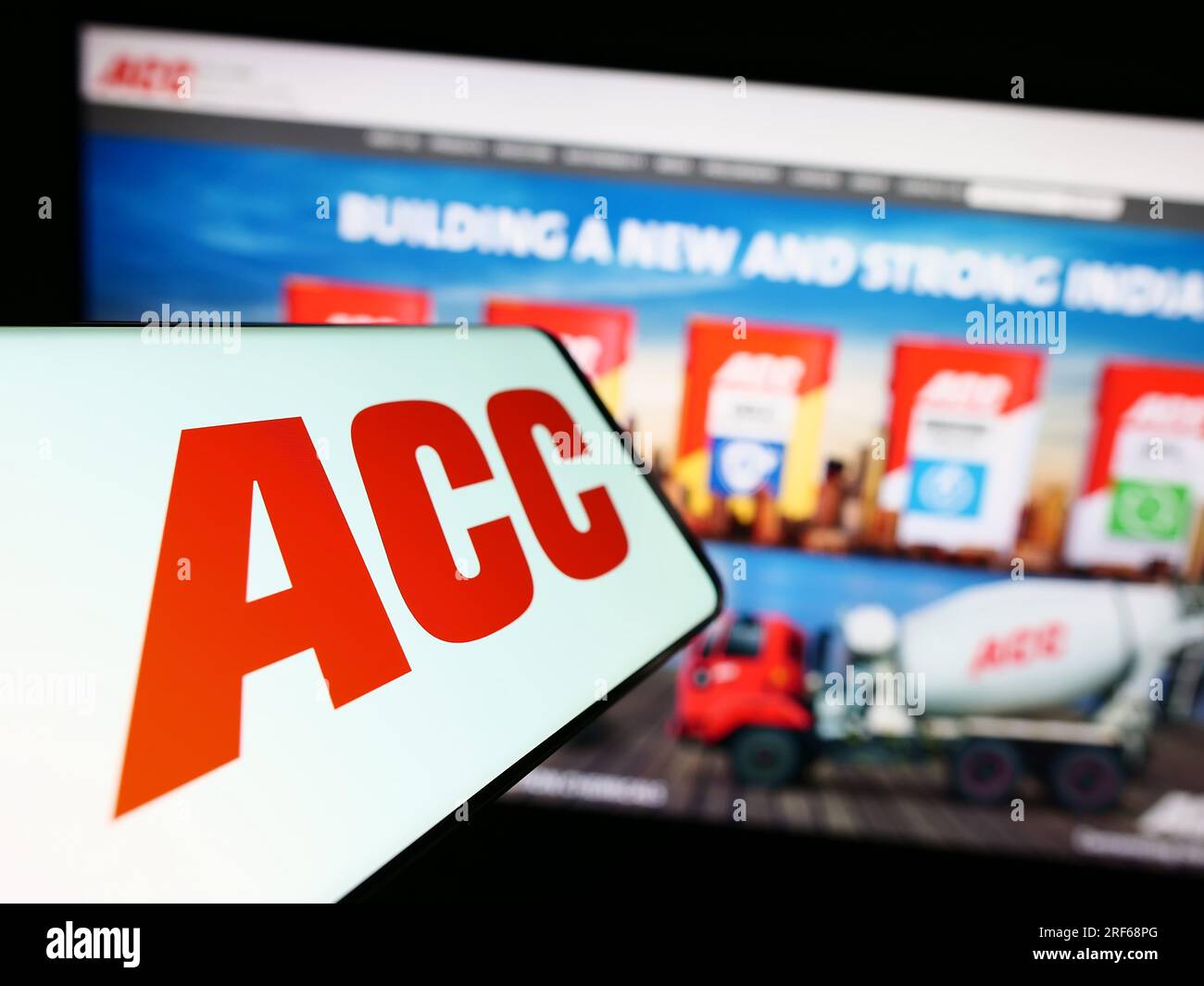 Smartphone with logo of Indian cement company ACC Limited on screen in front of business website. Focus on center-left of phone display. Stock Photo