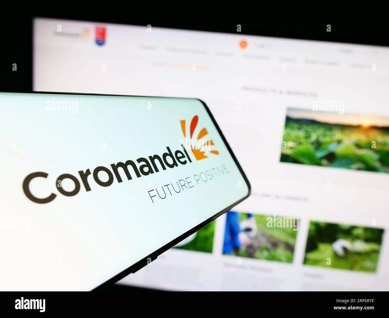 Cellphone with logo of Indian company Coromandel International Limited on screen in front of website. Focus on center-right of phone display. Stock Photo