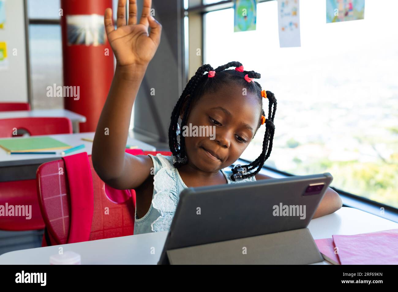 Happy african american schoolgirl having tablet video call in classroom ...