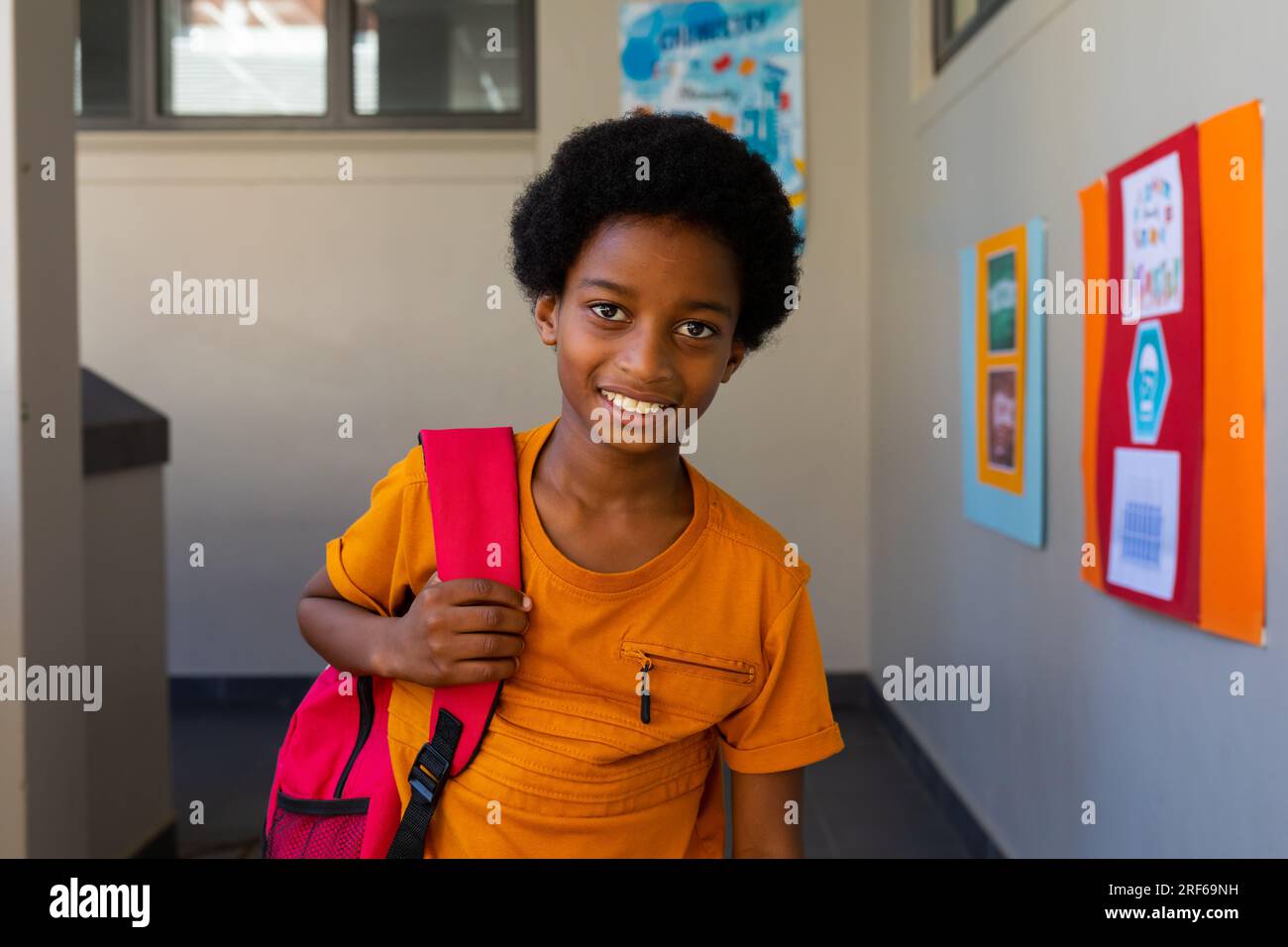 Portrait of happy biracial schoolboy with school bag at school Stock ...