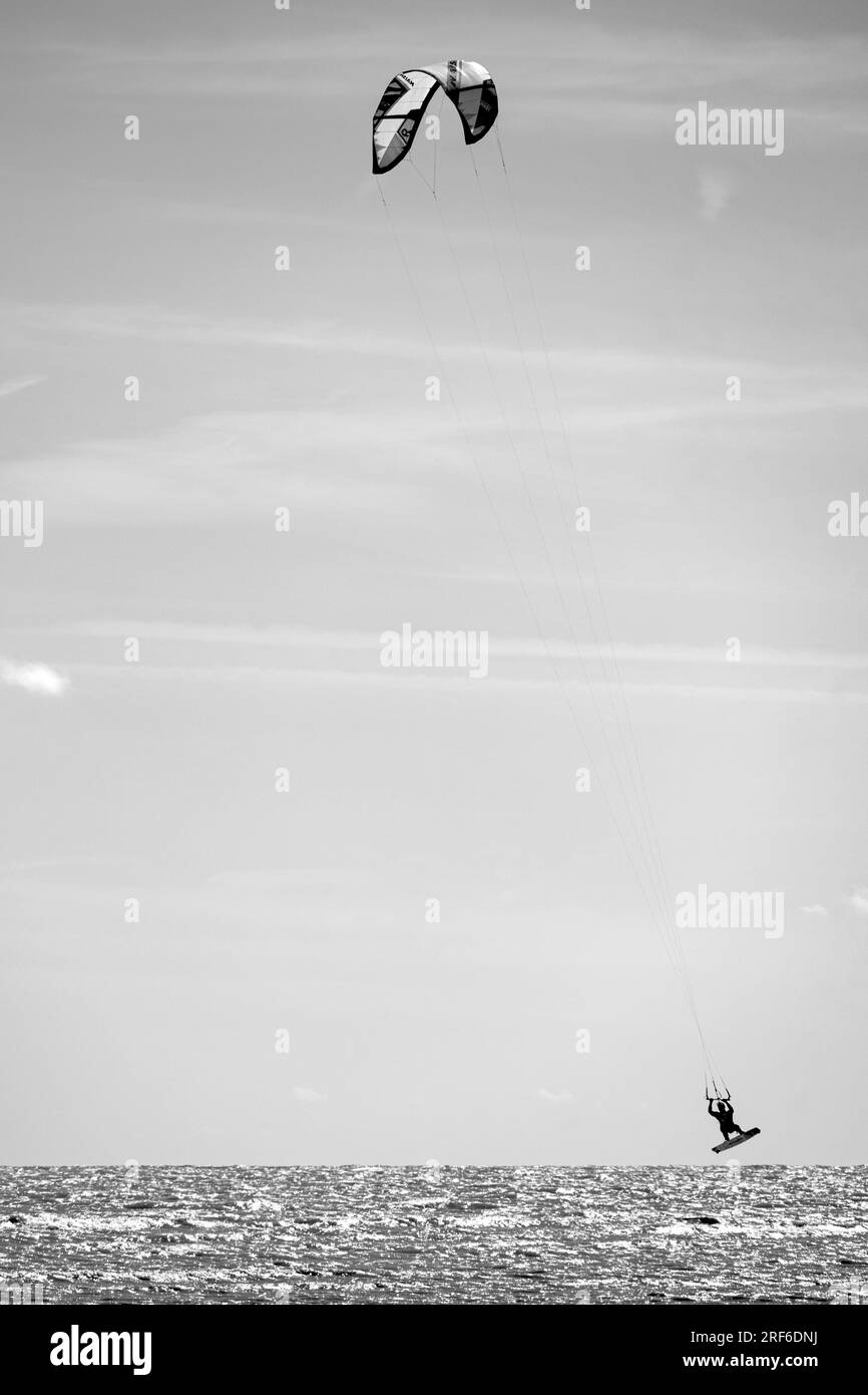 Black and white image of a kite surfer off the coast at Worthing, West Sussex, UK Stock Photo