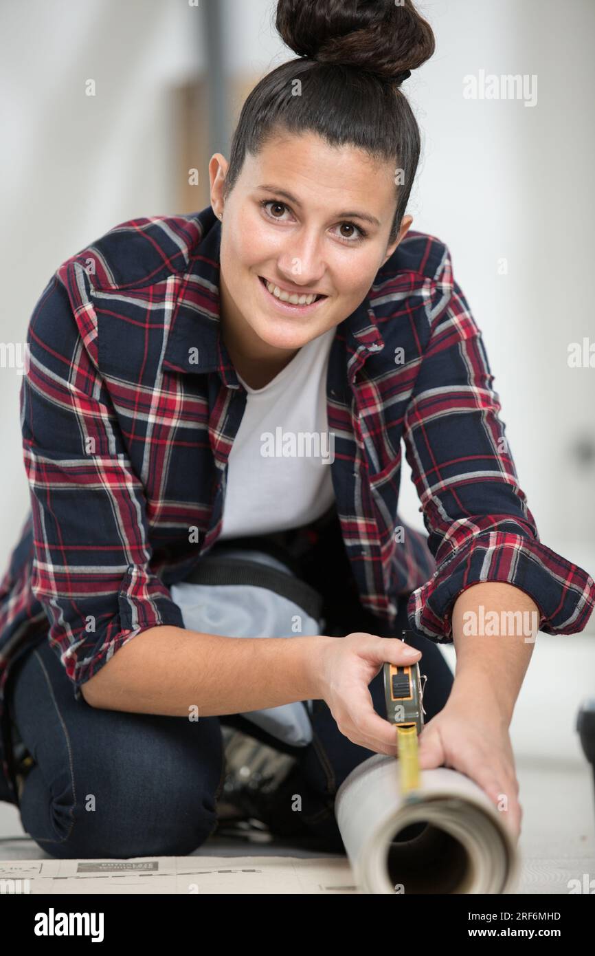 female worker is measuring the carpet Stock Photo