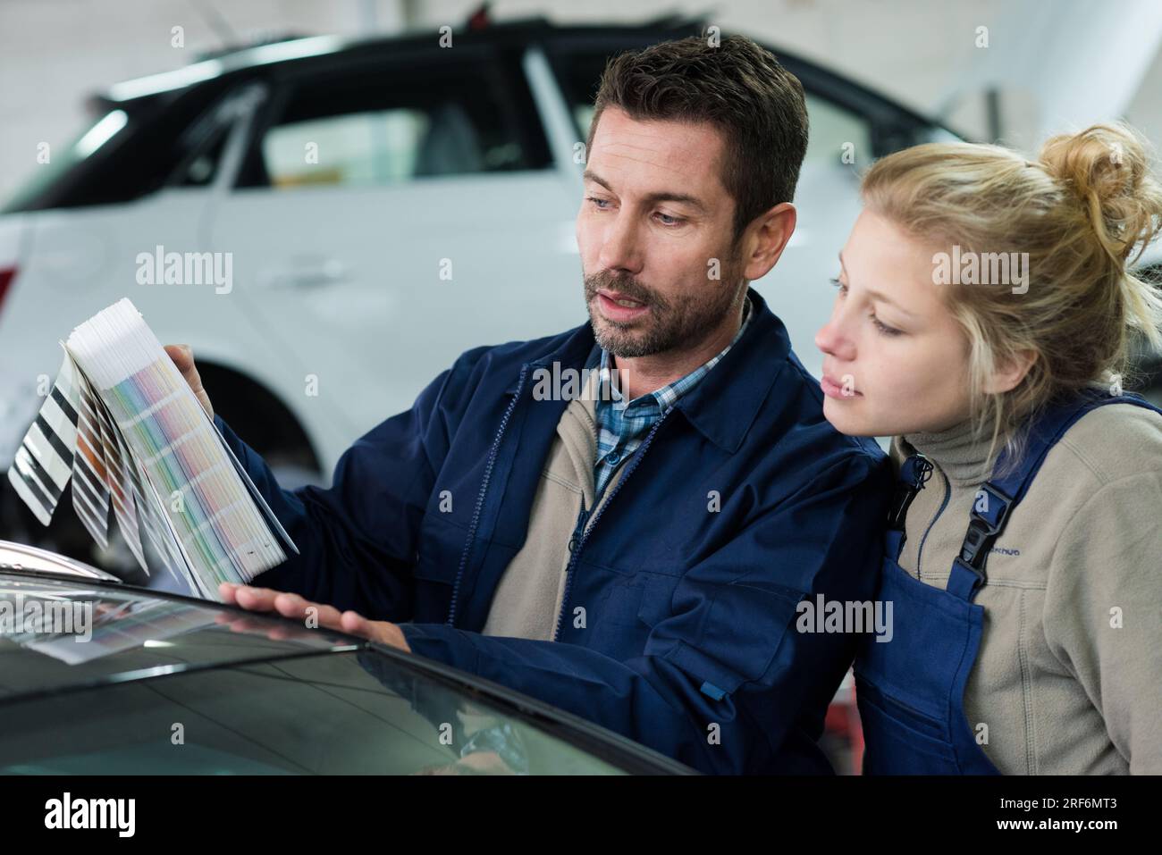 two mechanics with colour samples choosing correct shade for car Stock Photo