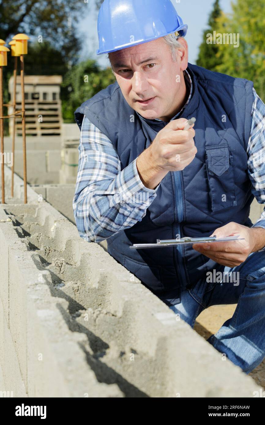 a builder checking concrete wall Stock Photo - Alamy