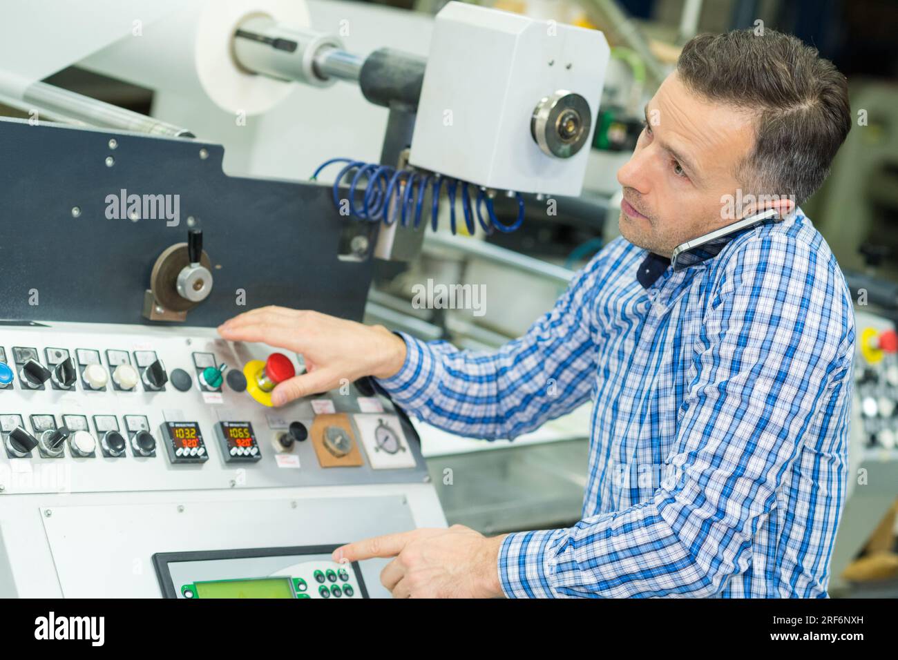engineer operating equipment in a small factory Stock Photo