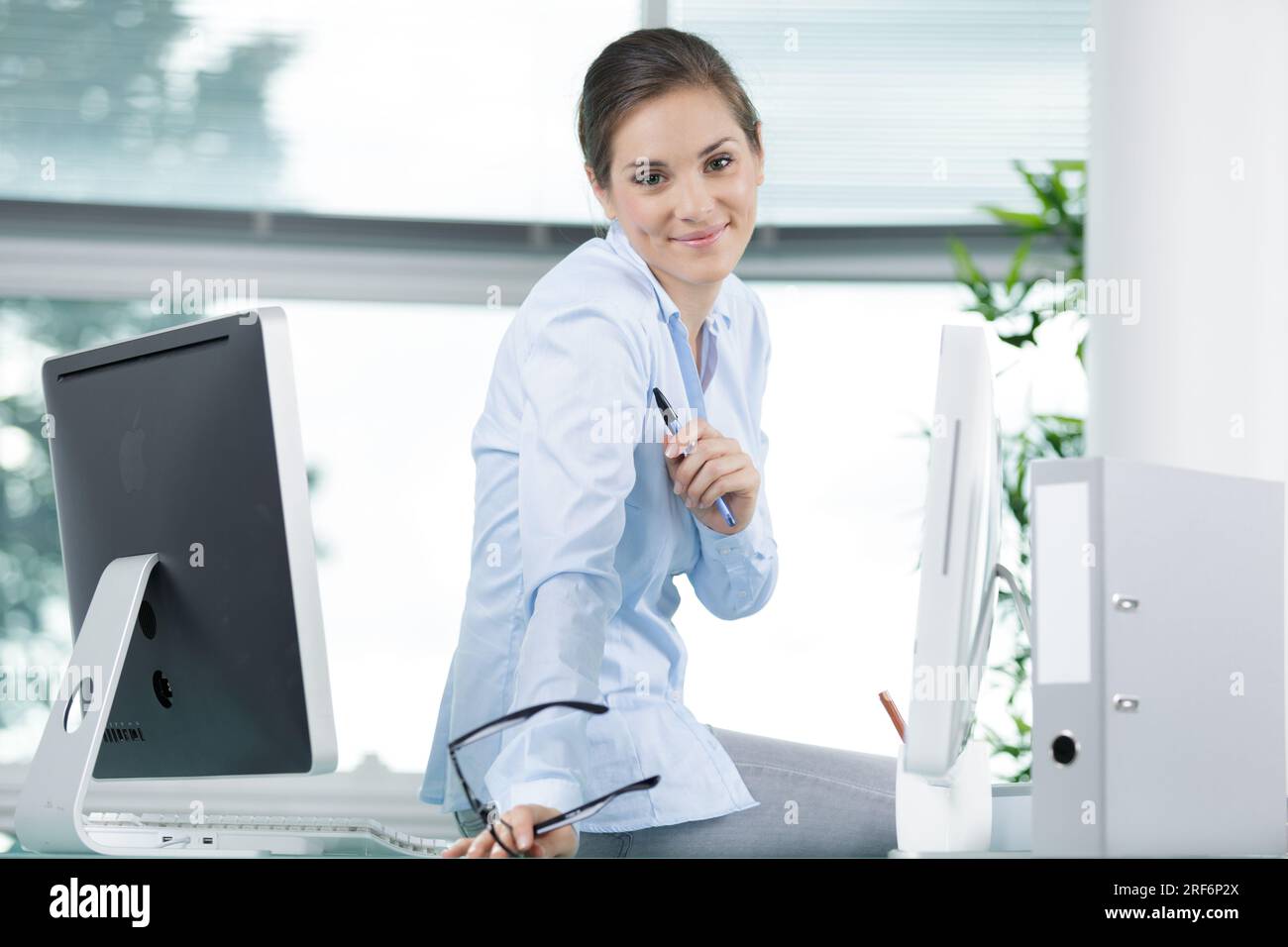 office worker holding eyeglasses looking at the camera Stock Photo