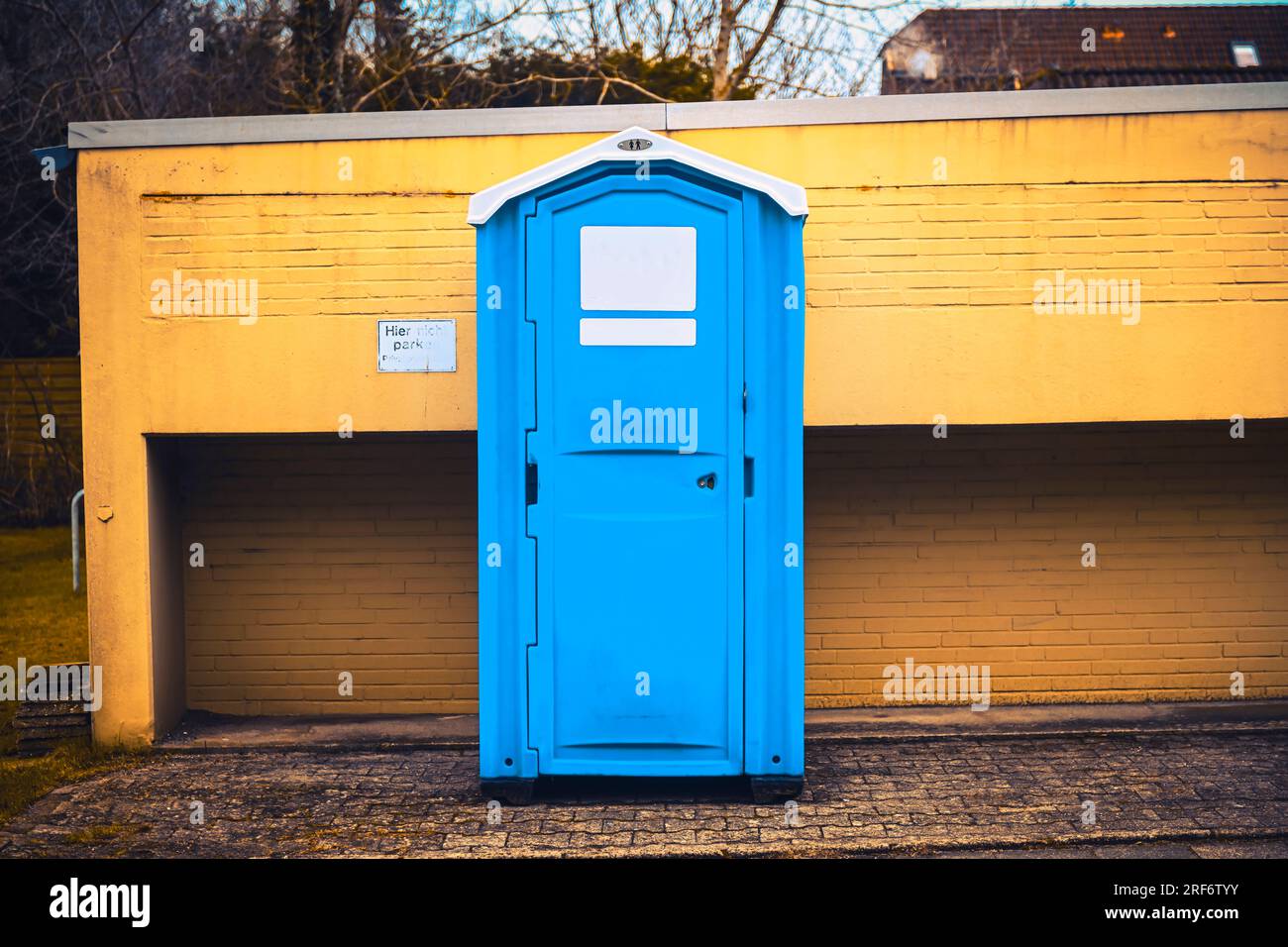 Mobile Toilettenkabine vor einer Mauer Stock Photo